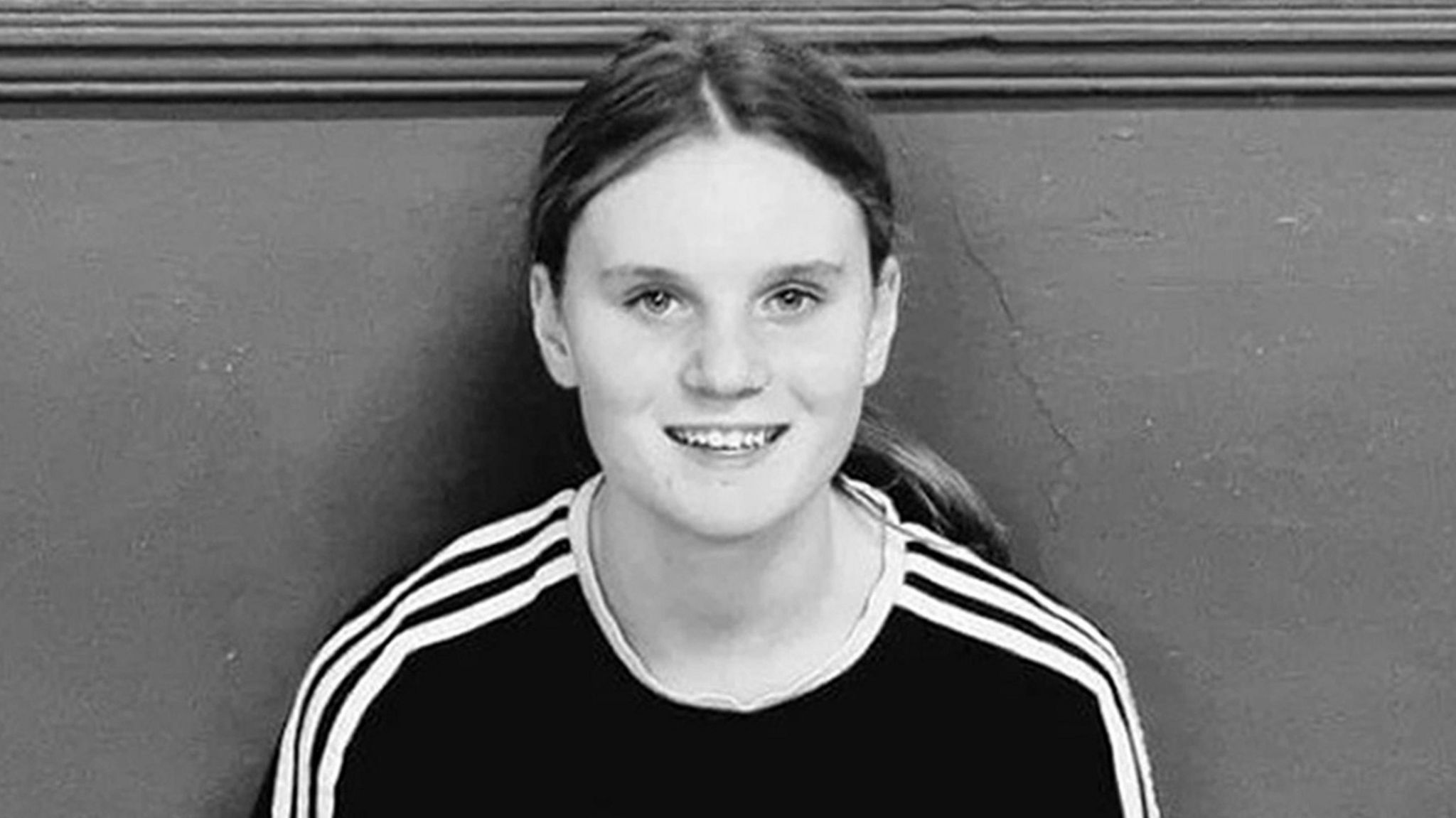 Black and white picture of a teenage girl with long hair in a pony tail