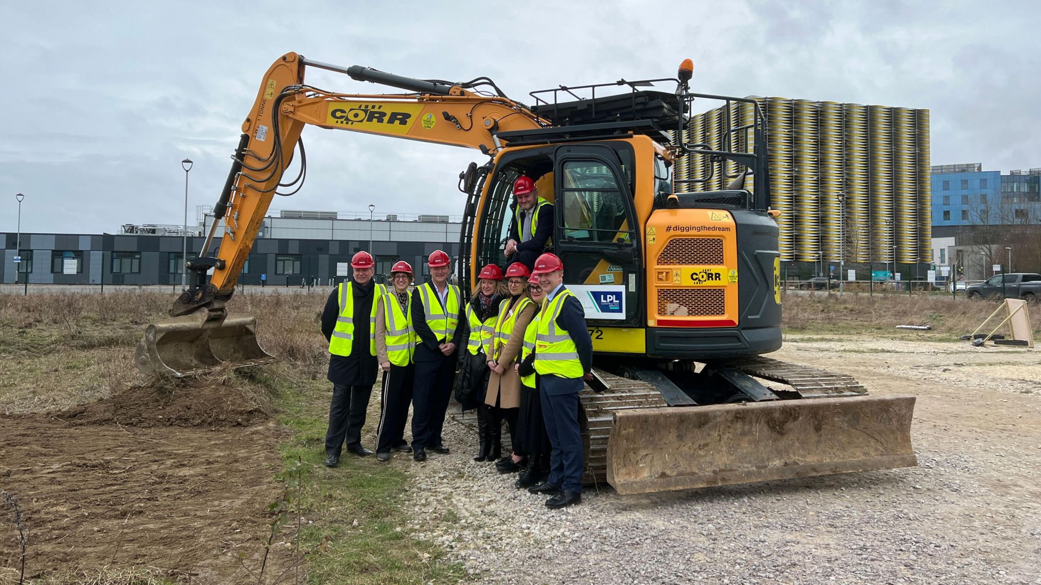 Andrew Stephenson and NHS staff in front of a digger
