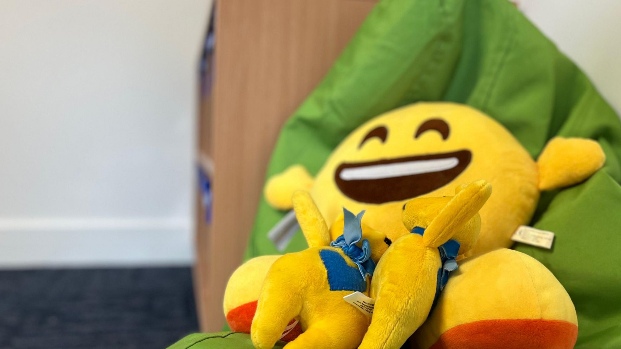 smiley face stuffed toy on a green bean bag