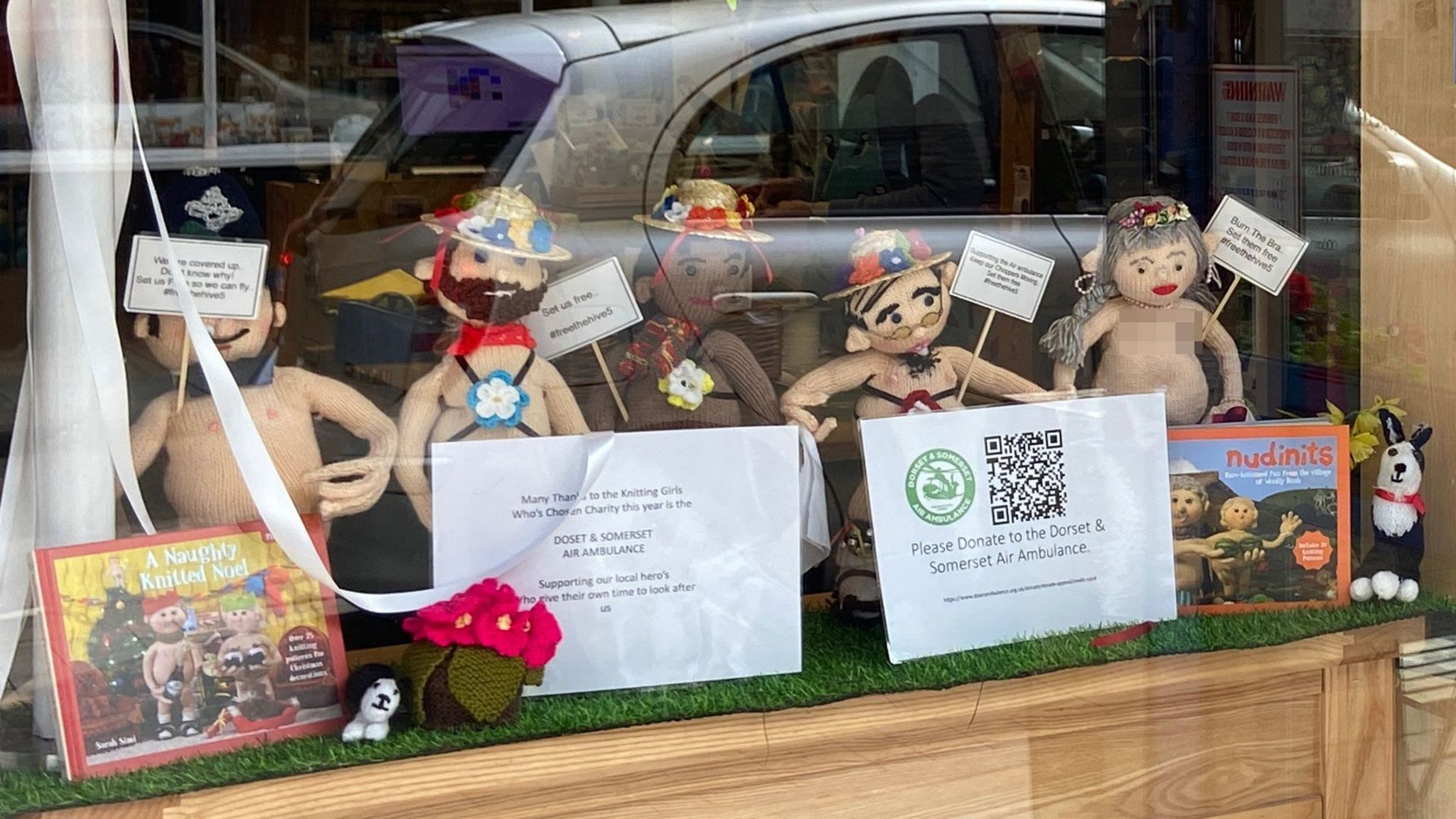 The five knitted figures have been covered up with books and paper