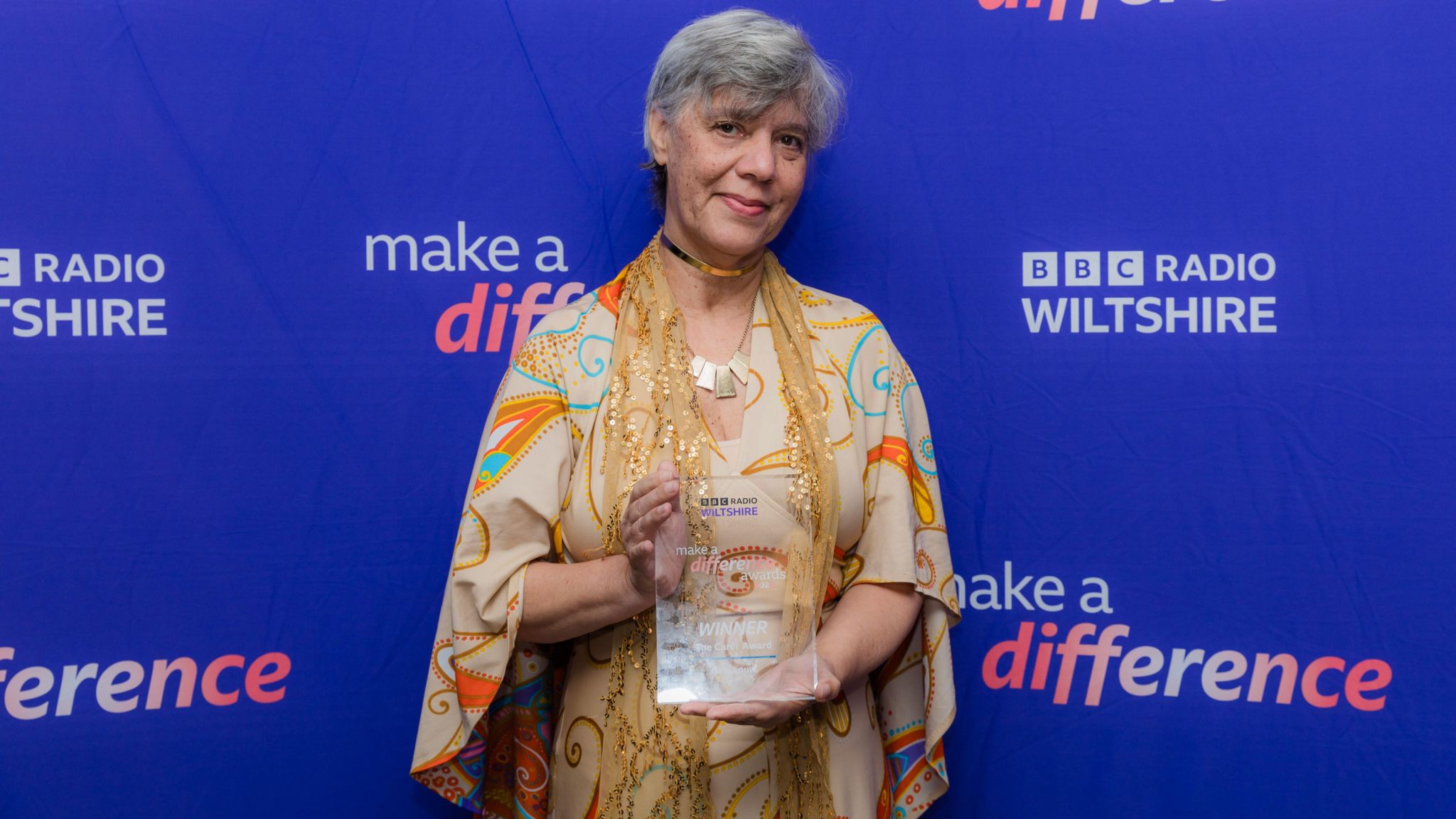 Gale holding her award in front of the BBC Radio Wiltshire banner