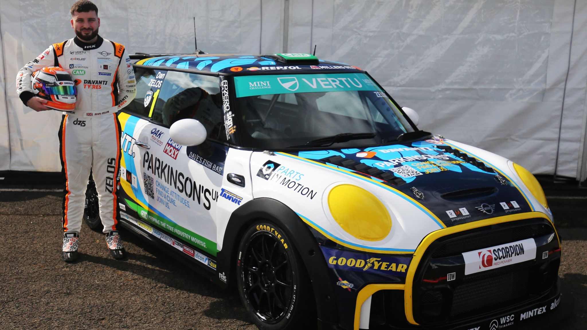 Dan Zelos stands by his racing car with his helmet off