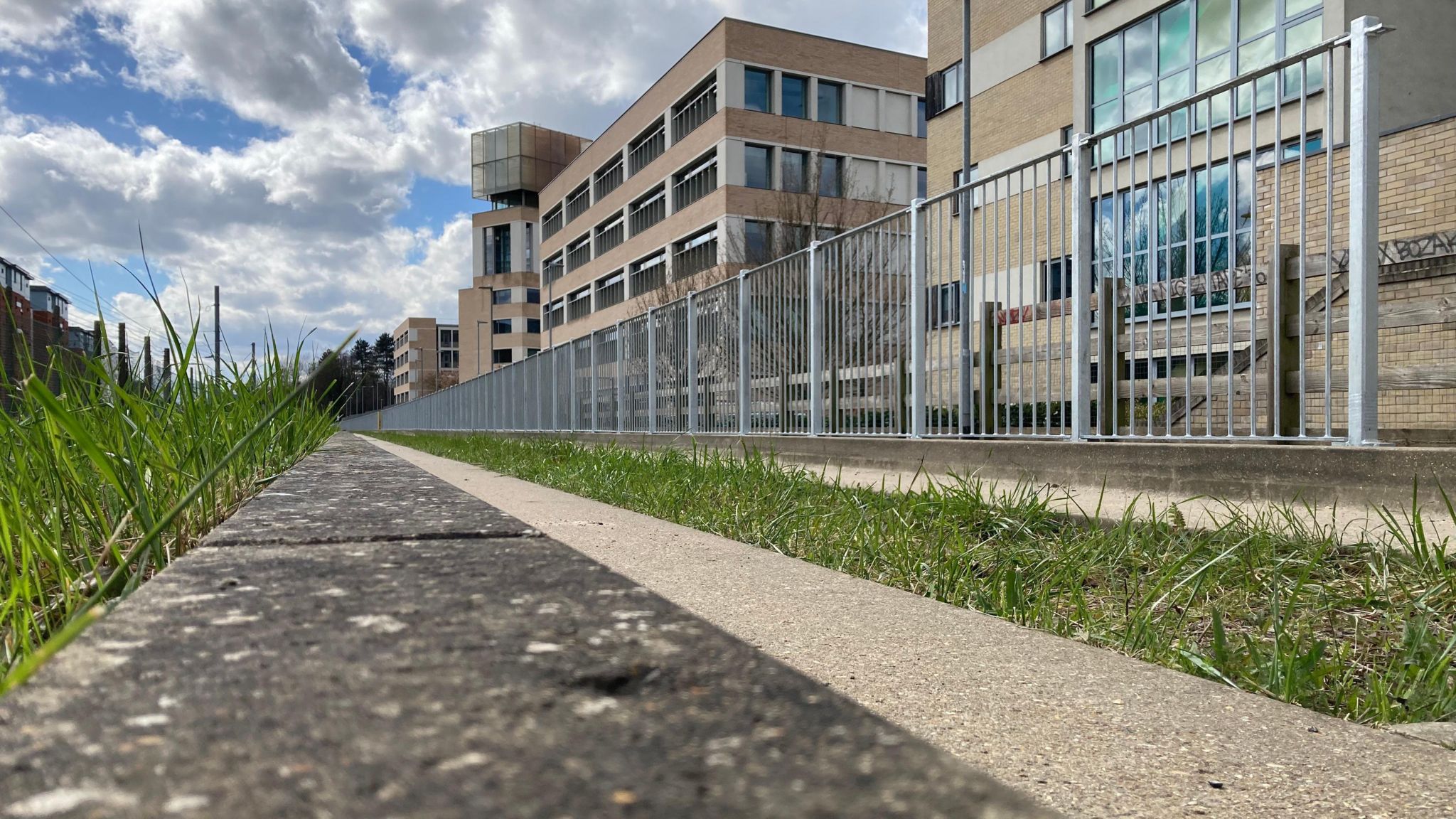 A busway with metal railings and buildings to the track