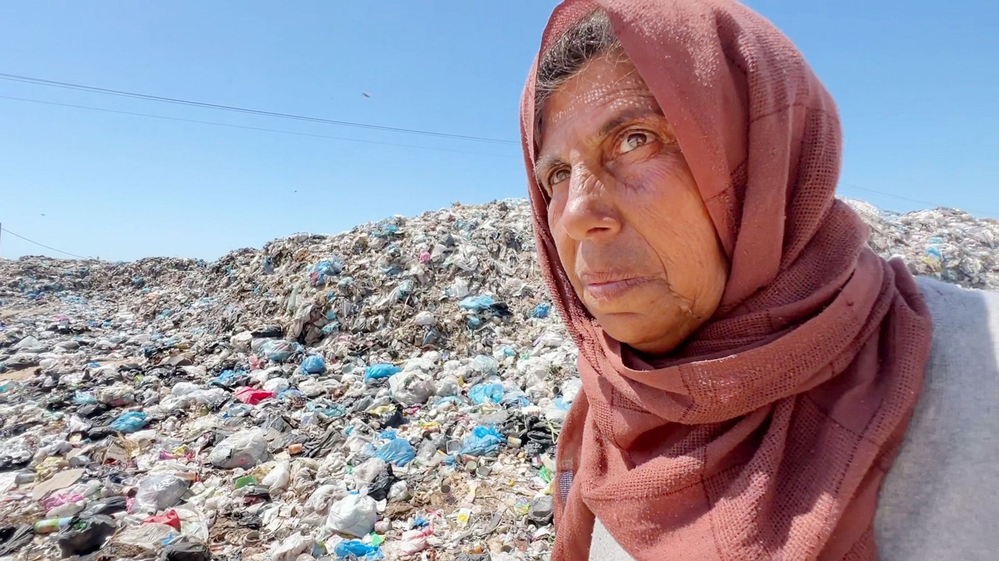 Close up shot of Asmahan standing in front of a rubbish heap