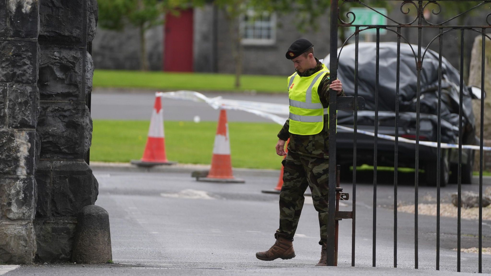 A uniformed member of the Irish Defence Forces holding a gate at Renmore Barracks