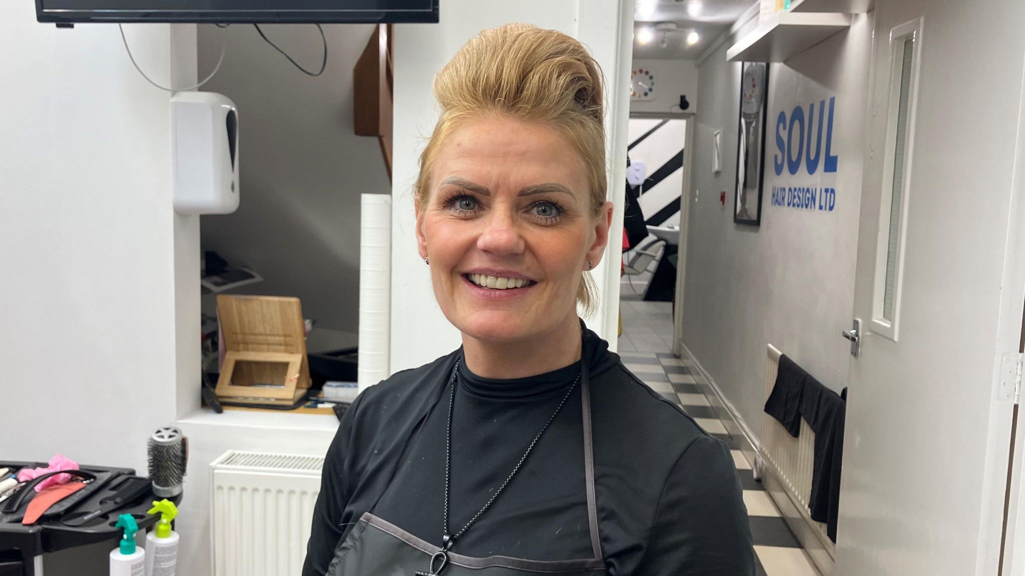 Hairdresser Denise Hall stands in her salon