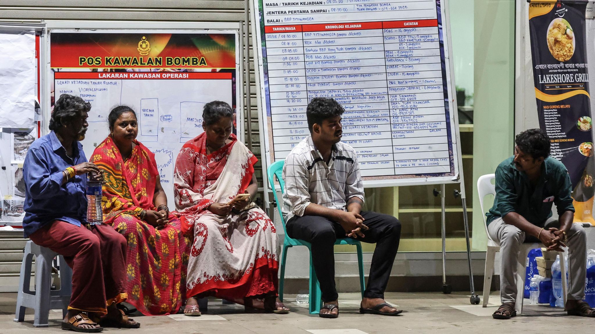 Relatives of an Indian woman who fell into an 8m deep sinkhole wait for news near the accident site in Kuala Lumpur