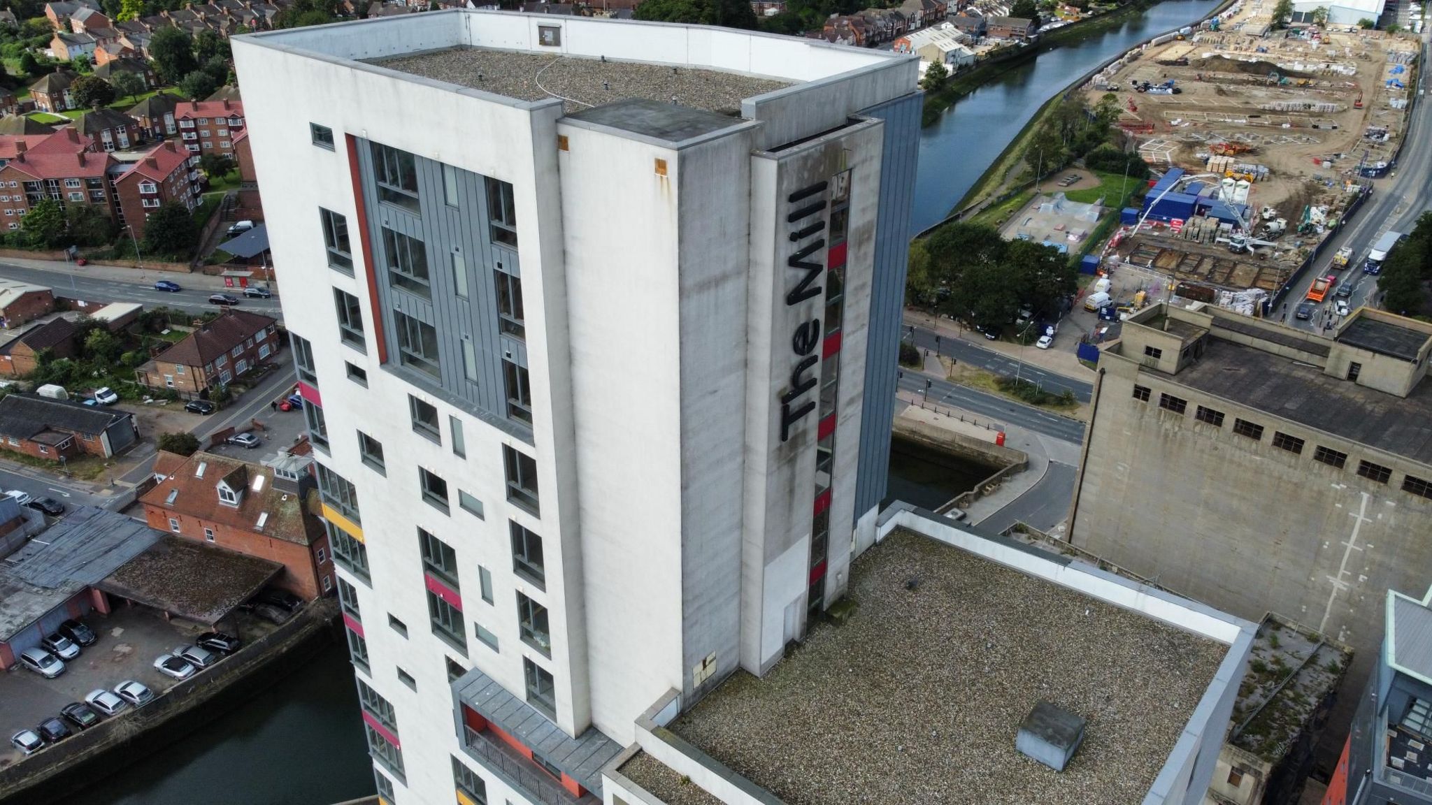 A drone picture of the top of The Mill tower block, a high-rise white and grey building