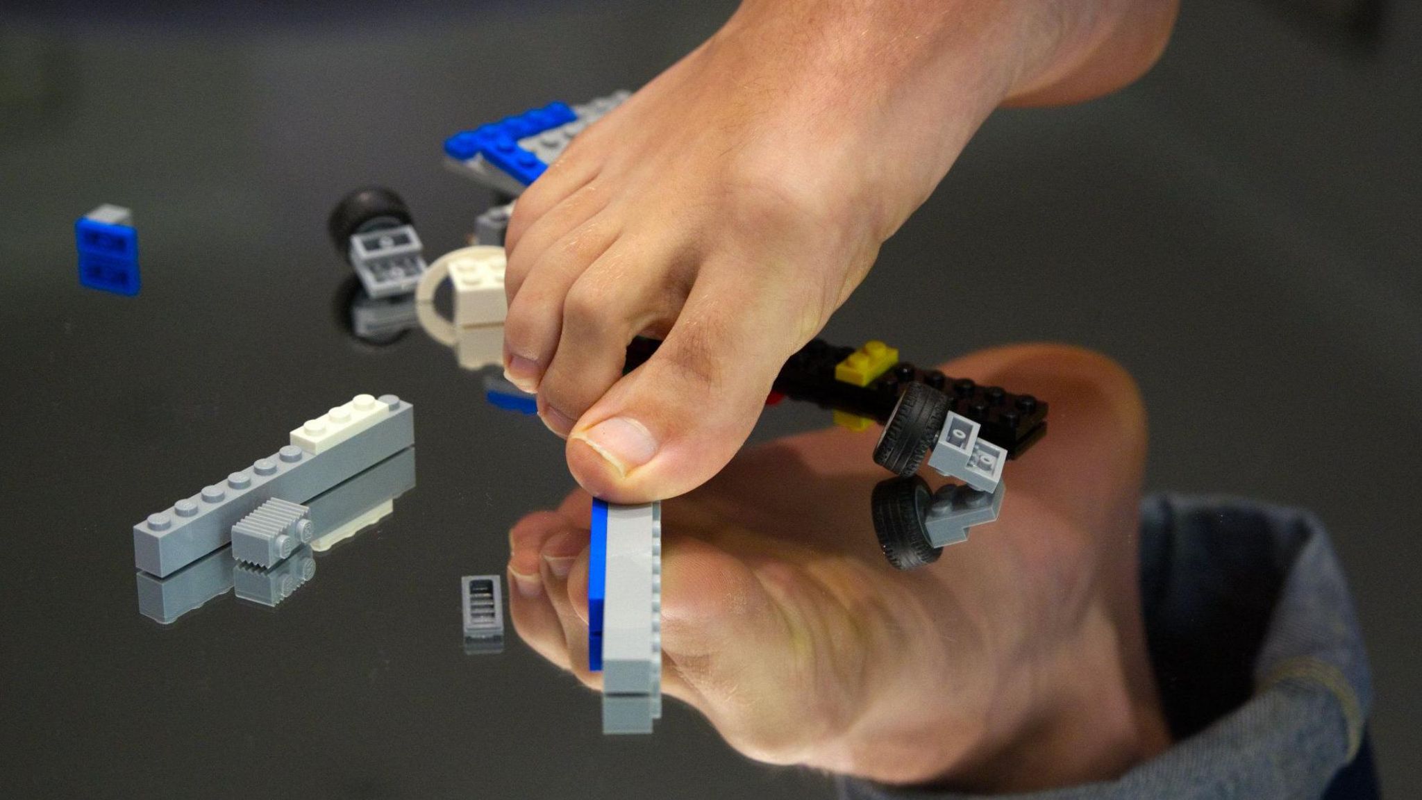 A foot stepping on some Lego