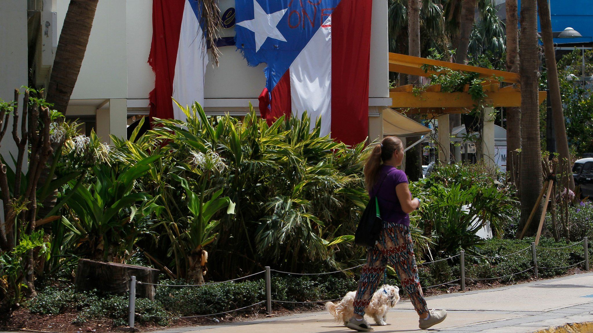 'Together as One' reads on a torn Puerto Rican Flag hanging from a hotel in the tourist zone of el Condado in San Juan, Puerto Rico on October 4, 2017