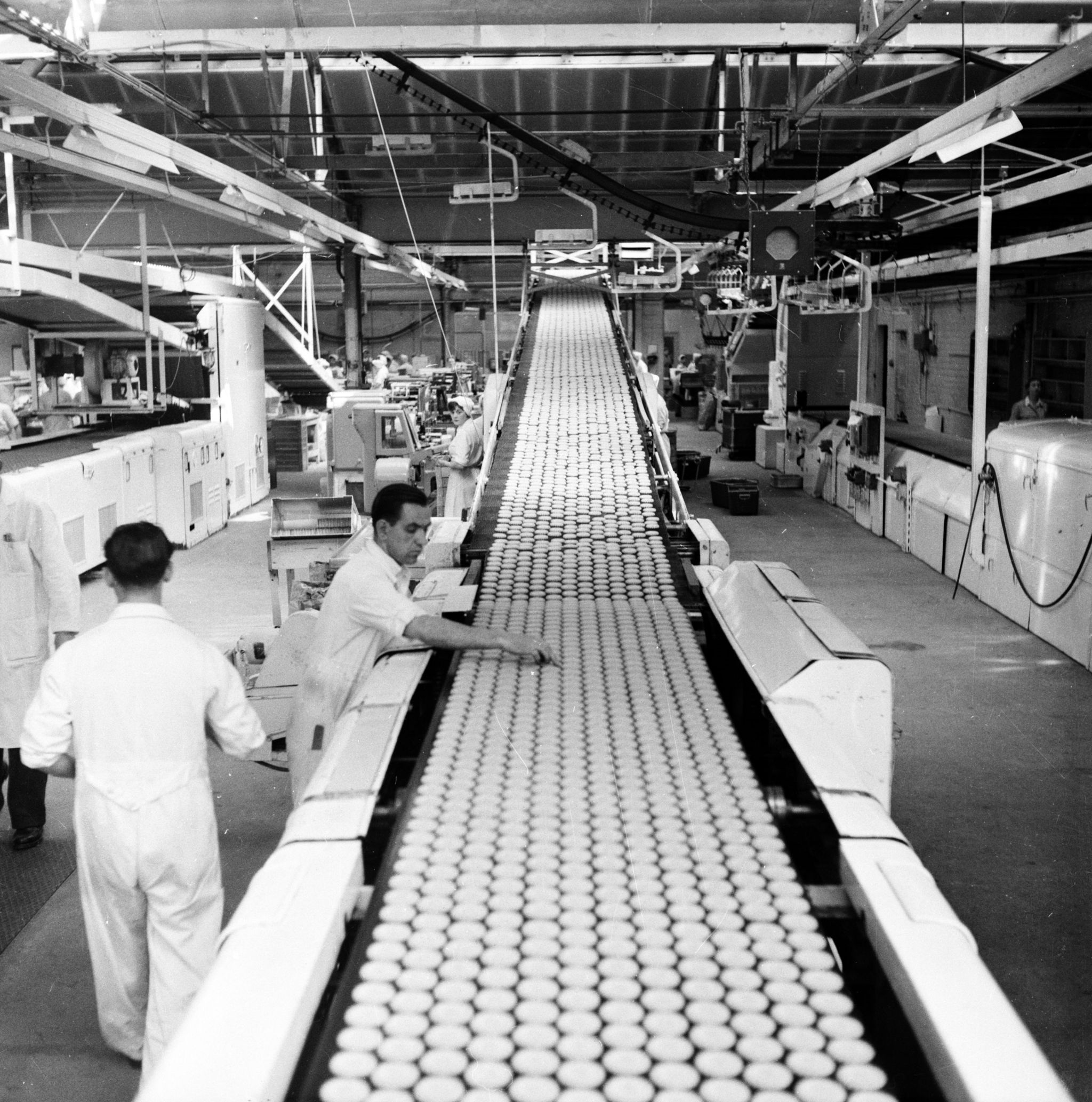 20th August 1955: Workers checking the quality of biscuits on a conveyor belt in the Glengarry Bakery of William Macdonald and Sons, Glasgow. This company's 2- hour production line generates a constant stream of biscuits and produces a quarter of Britain's total chocolate biscuit output. Original Publication: Picture Post - 7942 - Let Glasgow Flourish! - pub. 1955 (Photo by Haywood Magee/Picture Post/Hulton Archive/Getty Images)