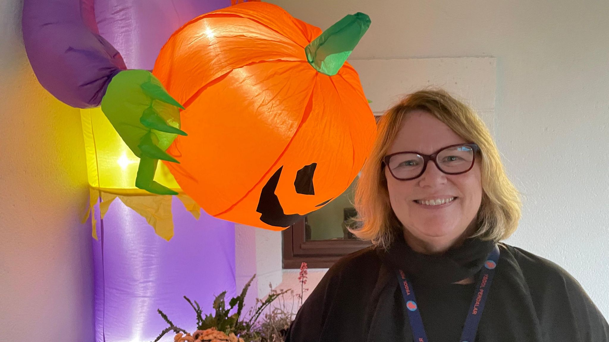 Bethan Morris Jones stood in from of halloween decorations, including a large orange inflated pumpkin head