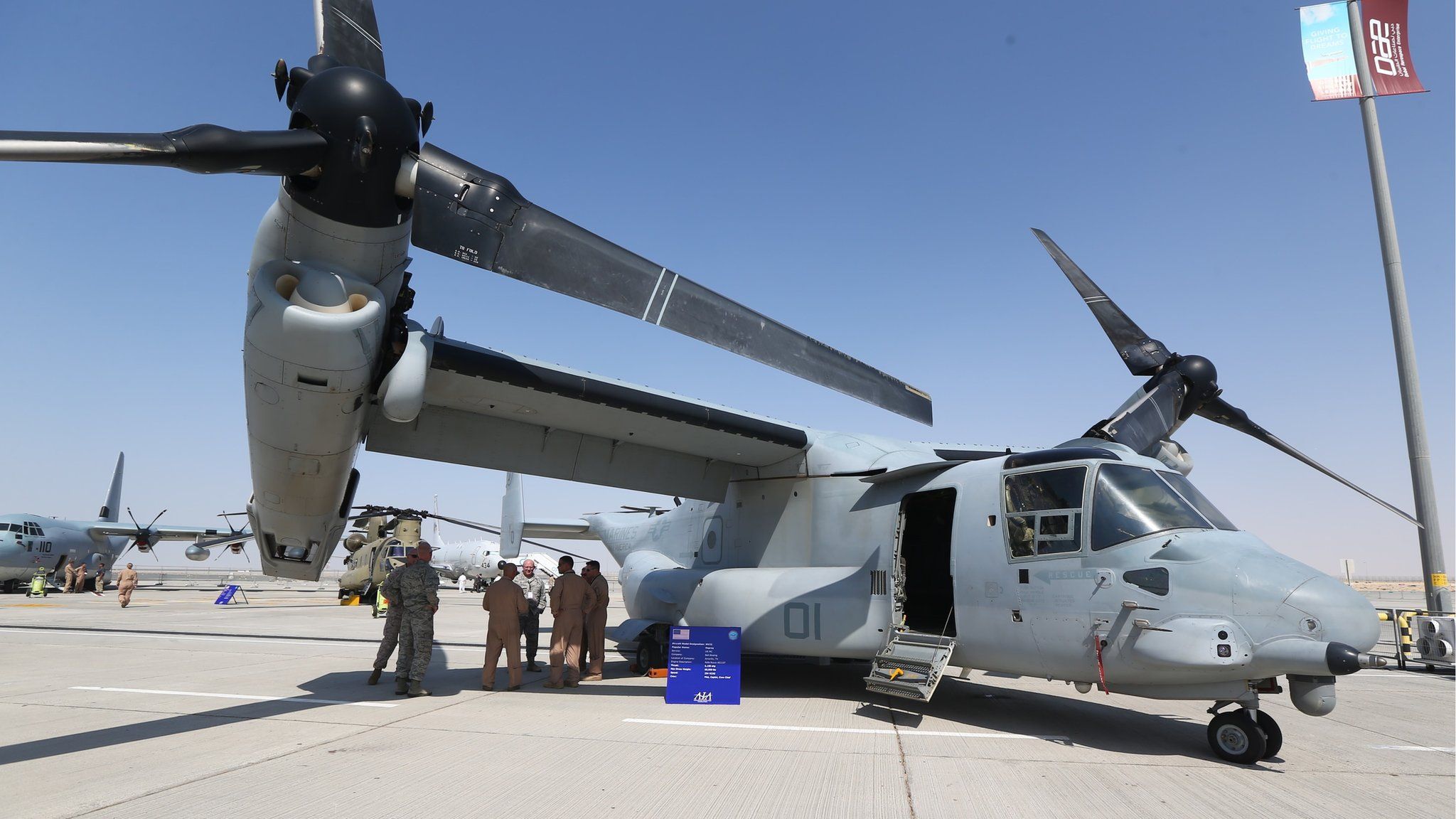 US soldiers stand in the shade of the wing of a Bell Boeing V-22 Osprey, a , tiltrotor military aircraft, at the Dubai Airshow on 8 Nov, 2015