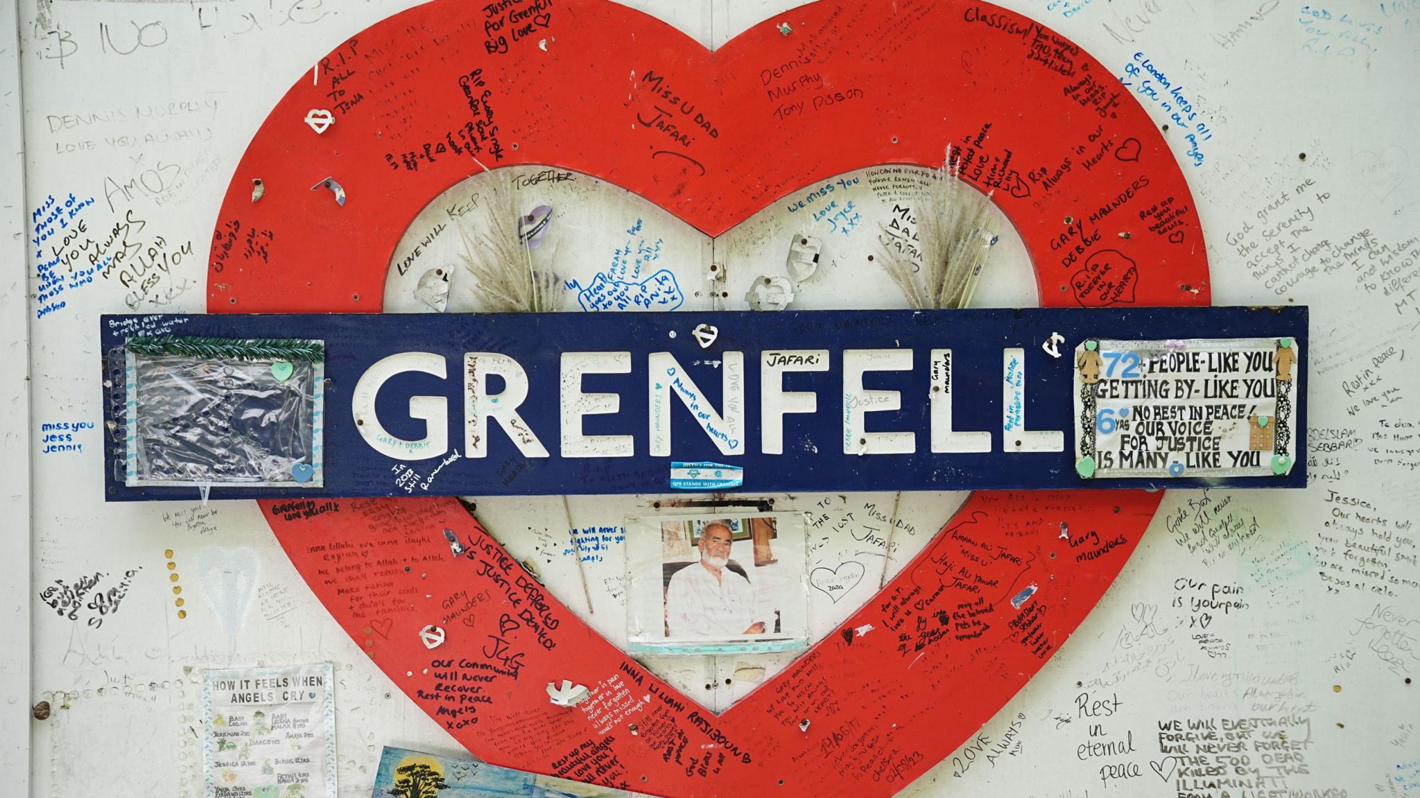 The hoarding around Grenfell Tower which shows messages of love and support surrounding an tube station style Grenfell sign in the shape of a love heart