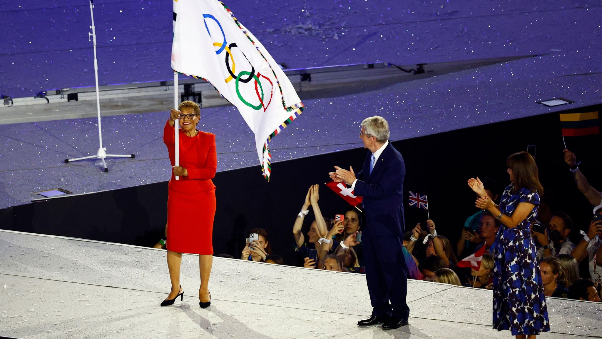 Karen Bass waves the Olympic flag