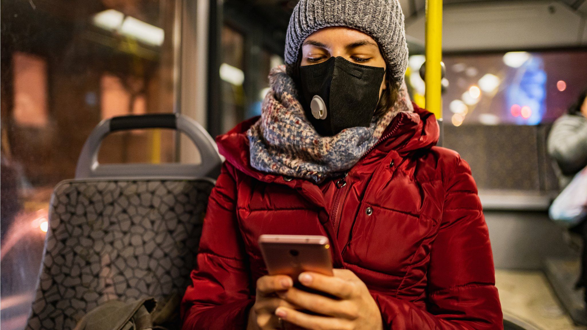 Woman wearing a mask on a bus in winter