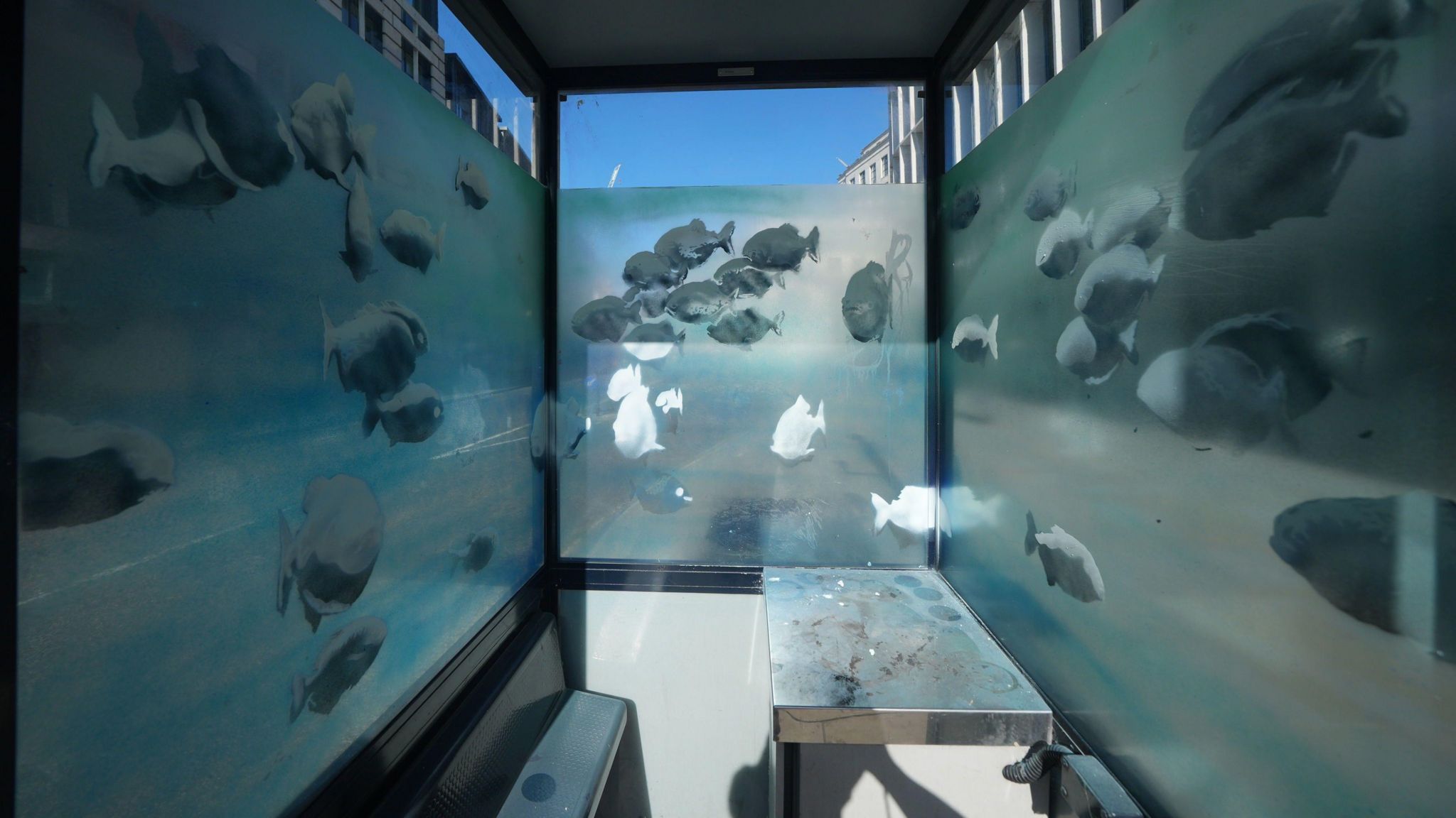 Possible Banksy artwork of a shoal of fish on the windows of a police sentry box in London