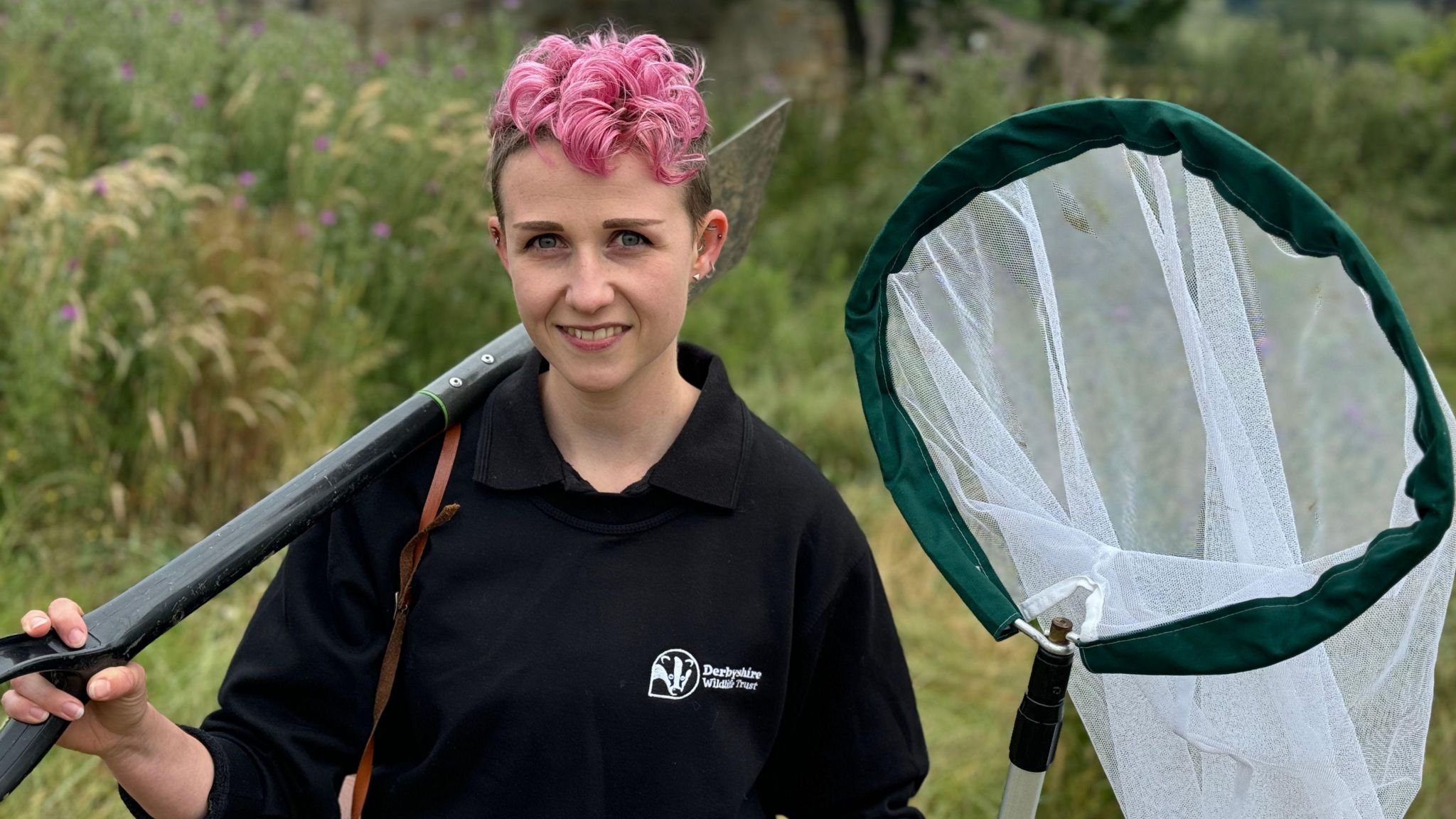 Pink-haired ecologist with a spade and a net