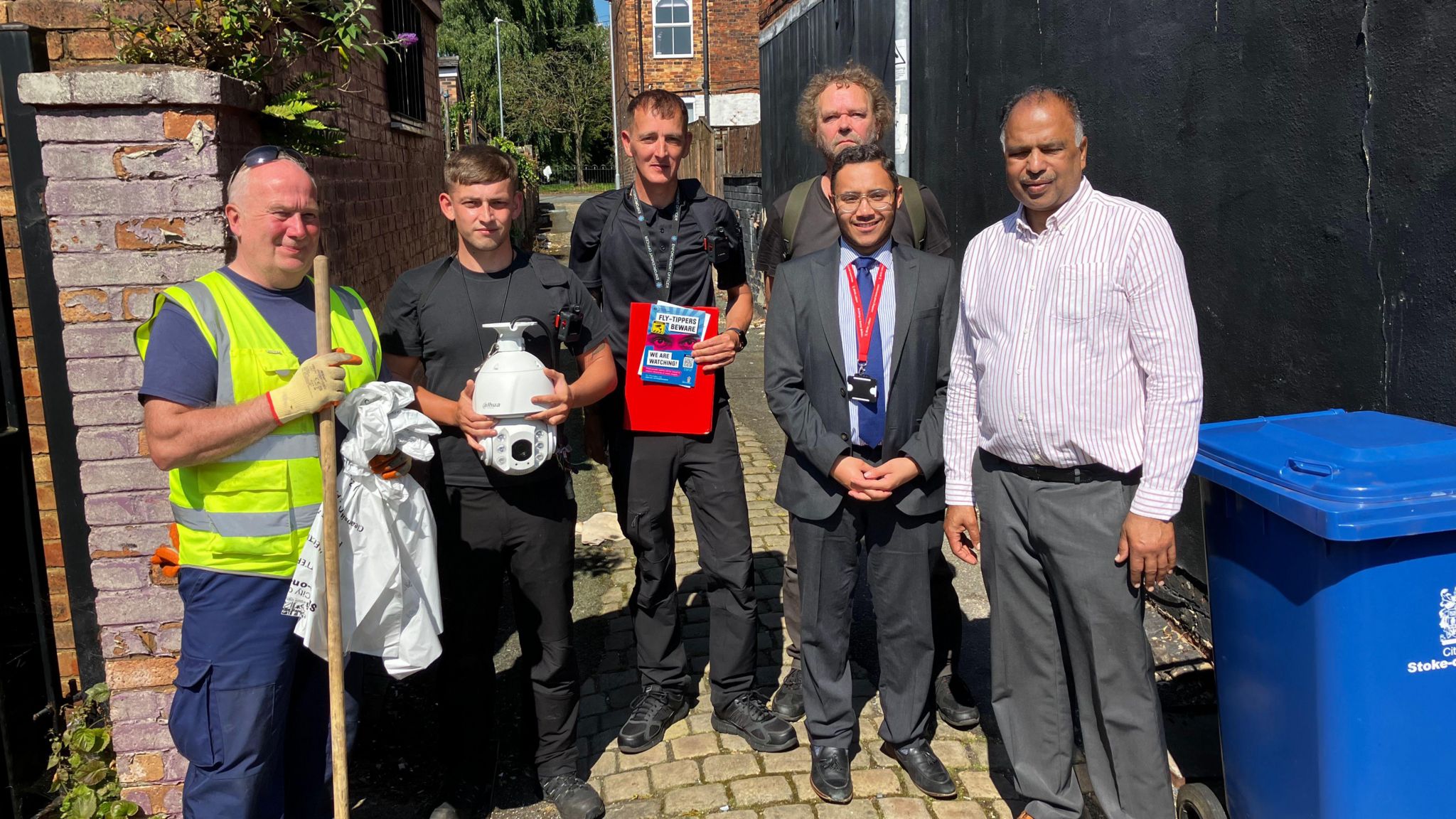 Launch of Love Your Street campaign. Six men look at the camera, including one holding a stick and bags and wearing gloves. 