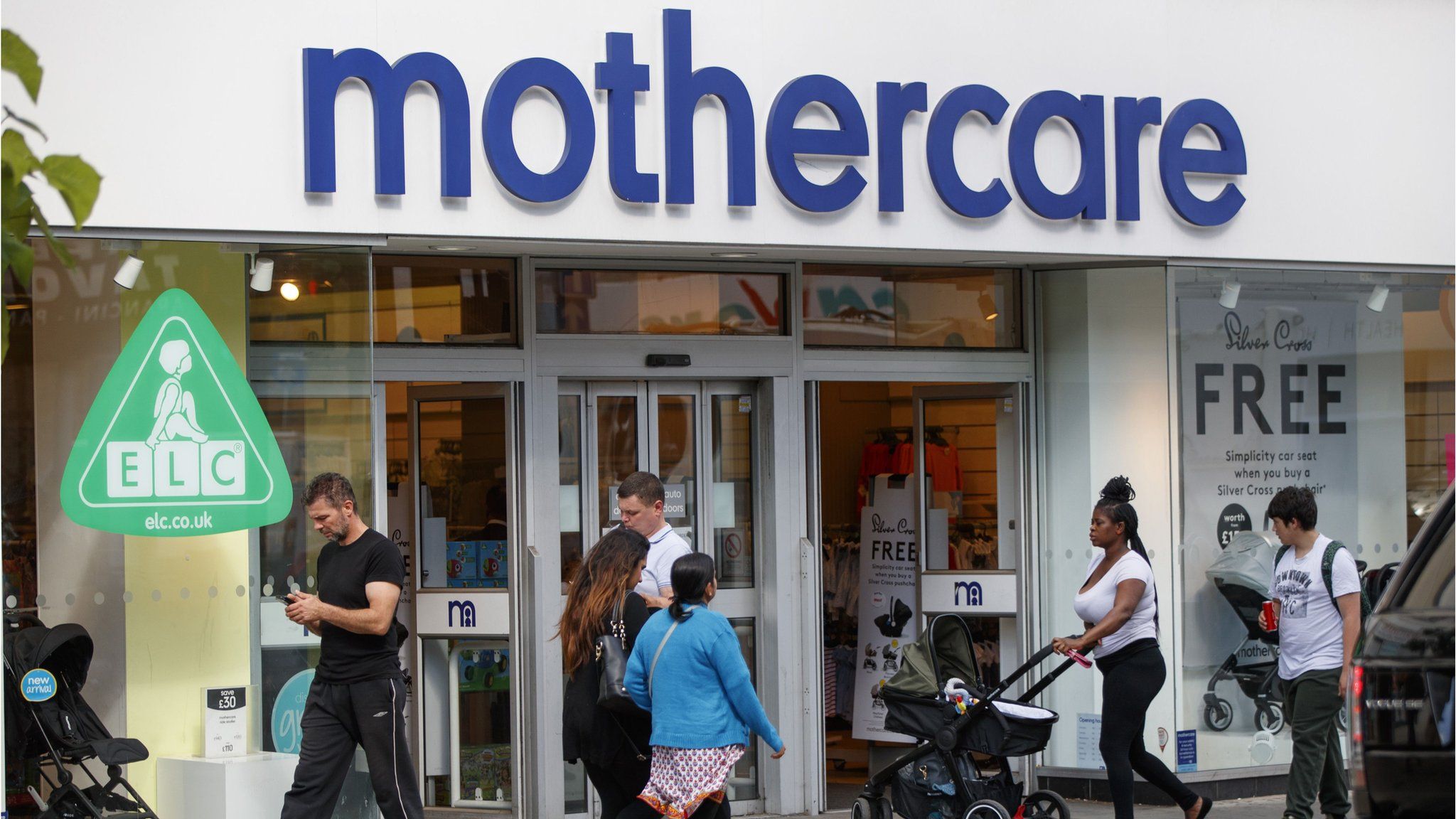 Shoppers walk past a Mothercare shop on Wood Green High Street in north London on June 19, 201