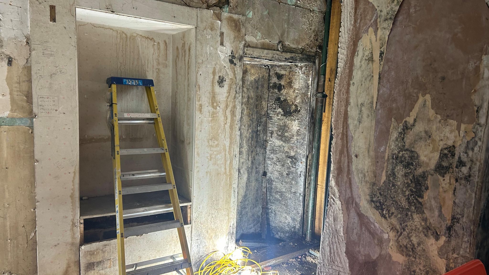 A ladder, some lights and a giant alcove with dripping water on the ground floor inside the former House of Fraser building in Cirencester