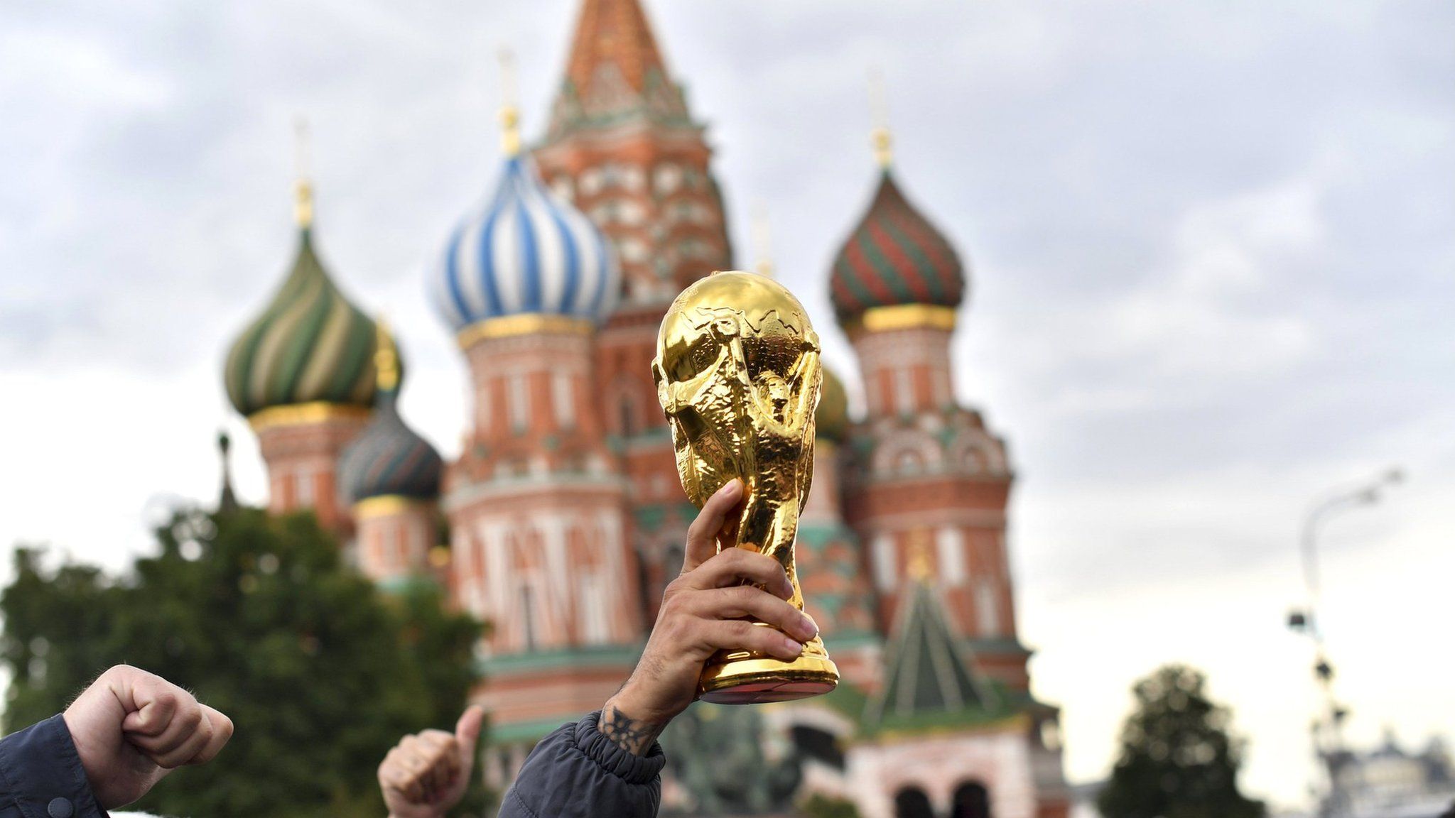 Colombian fans hold a fake World Cup trophy in front of Saint Basil's Cathedral in Red Square, Moscow