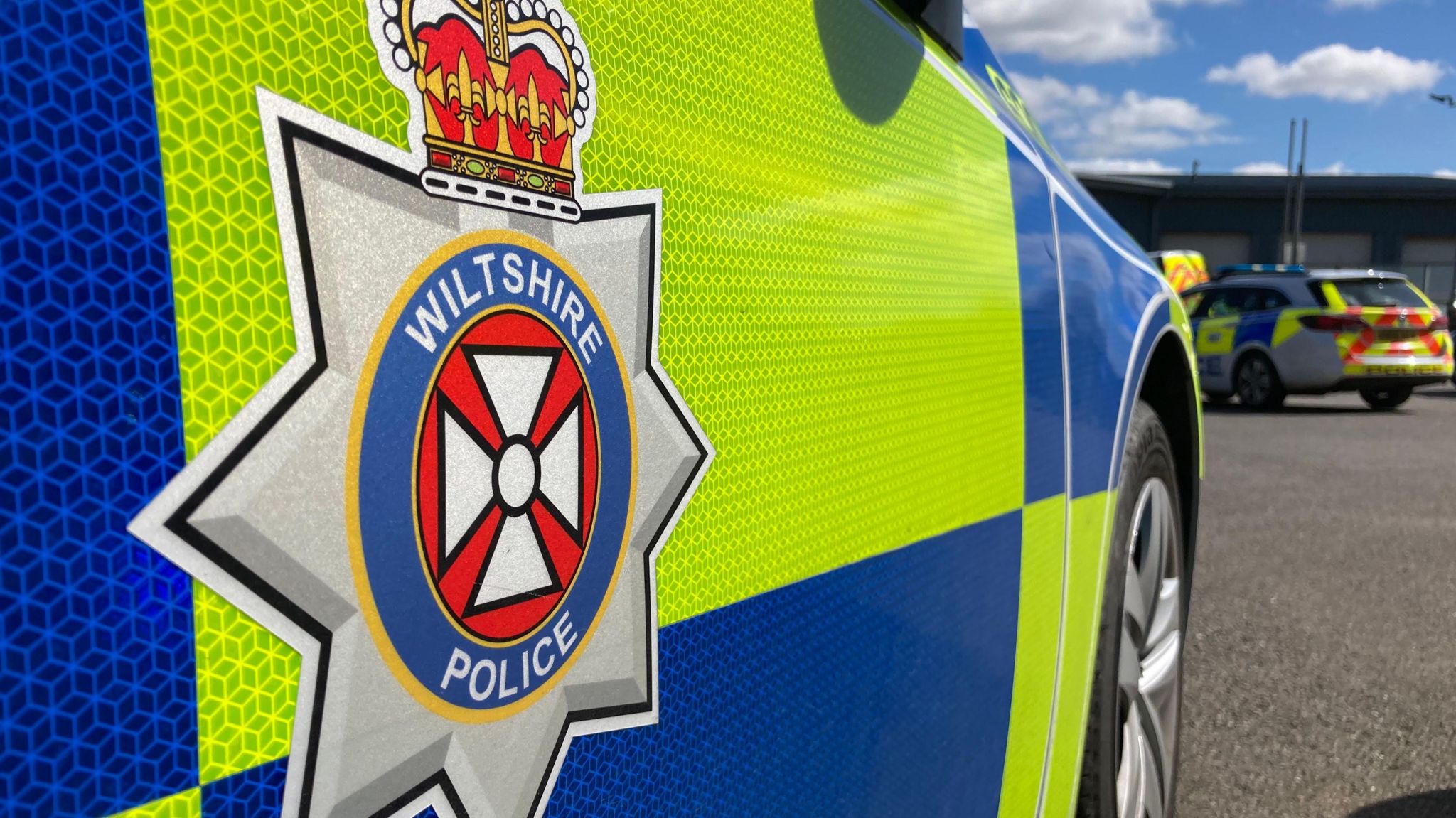 A Wiltshire Police force emblem on the side of a police car