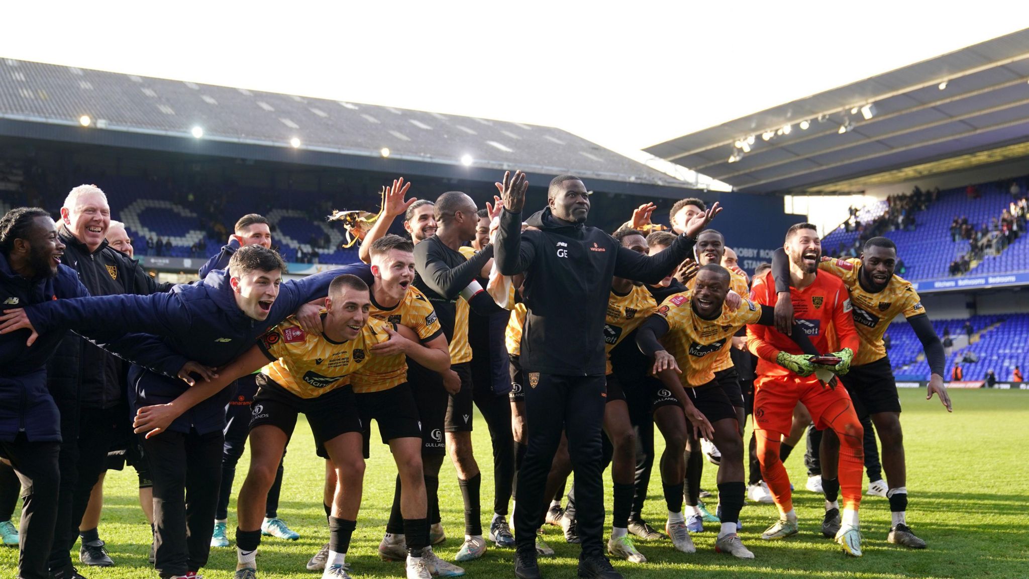 Maidstone United's players and management celebrate on the pitch at Portman Road in front of their fans