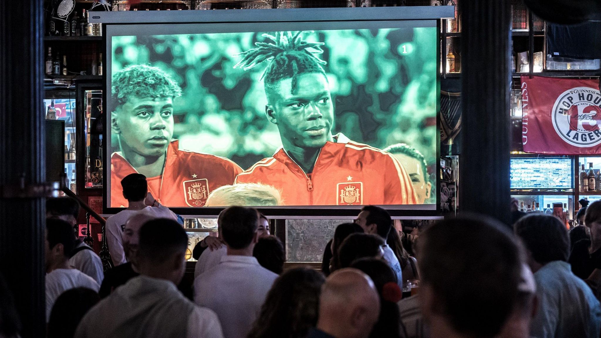 People watching a Euro football match on a TV screen