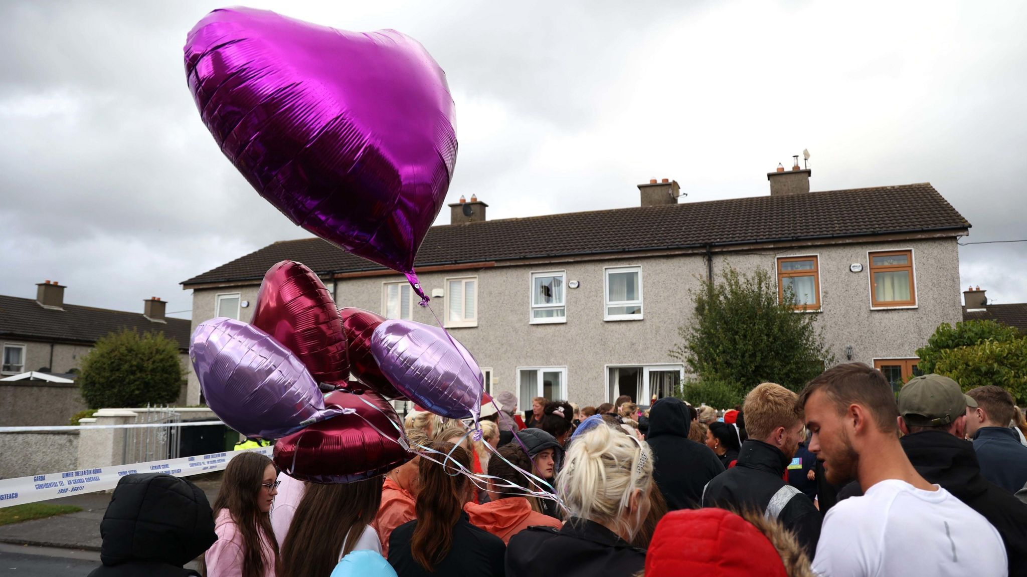 A vigil was held outside the house on Rossfield Avenue hours after the triple murder