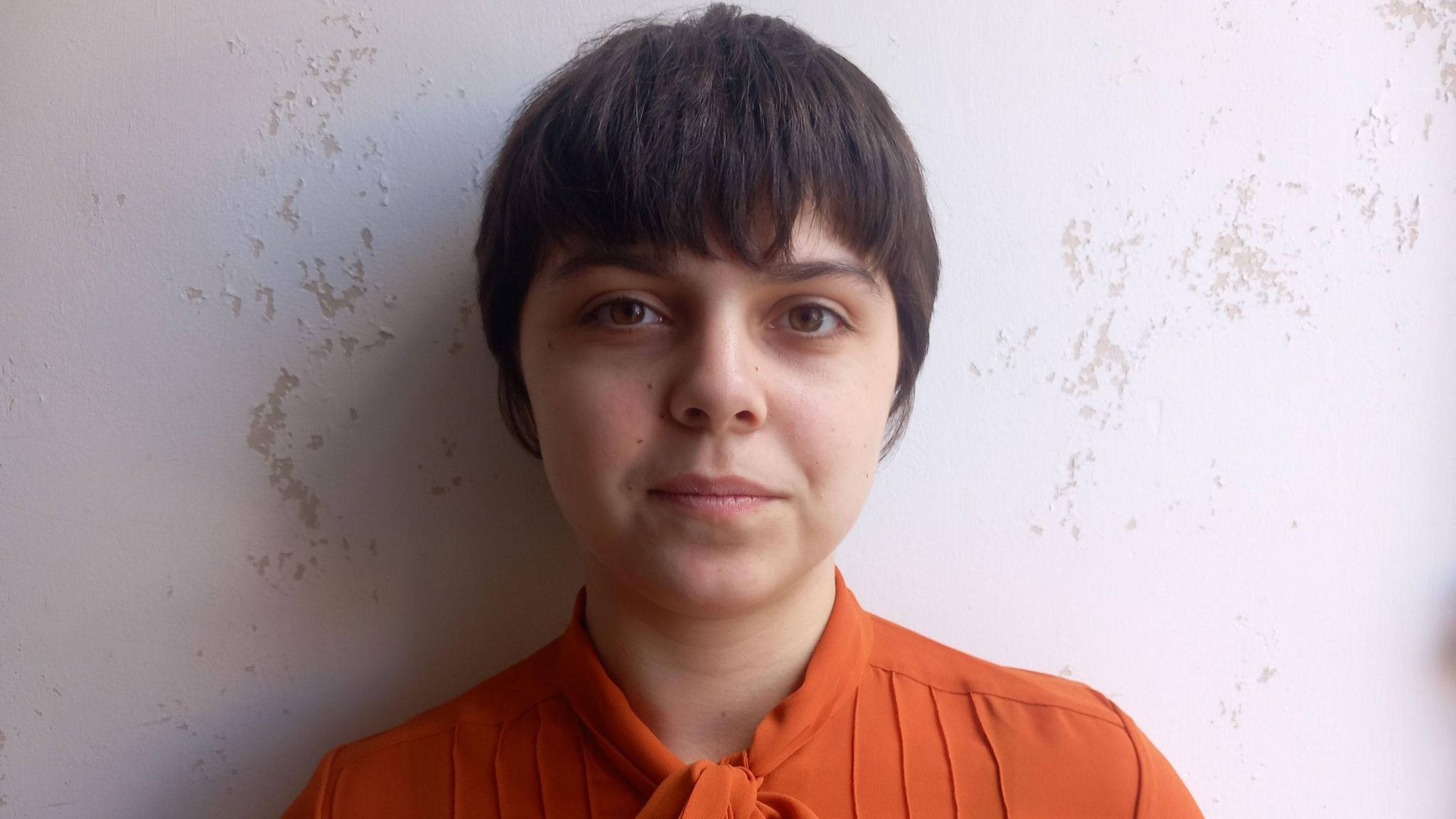 Tallulah Martinez with short hair and wearing an orange top