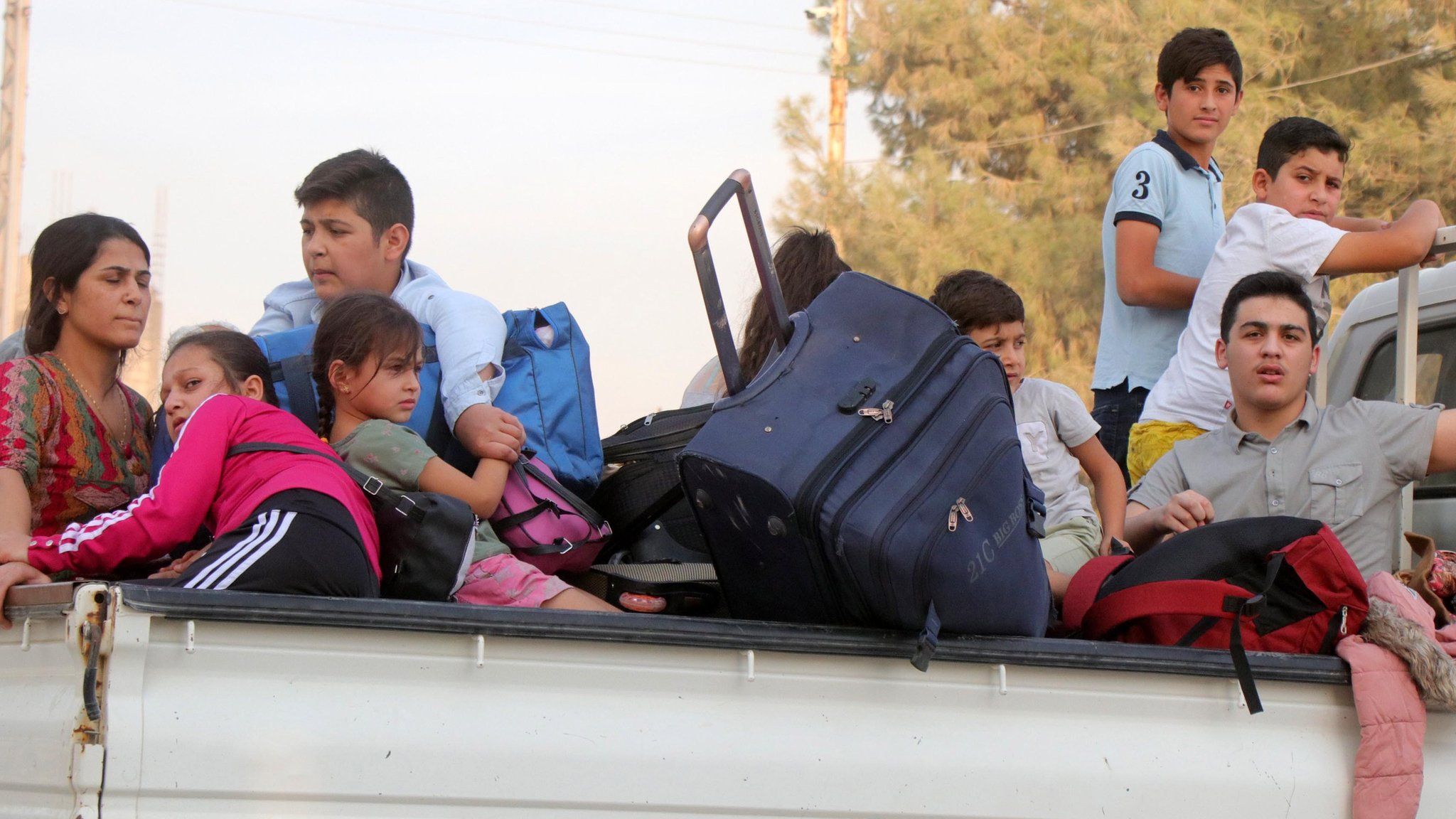 Families flee the town of Ras al-Ain in north-east Syria (10 October 2019)