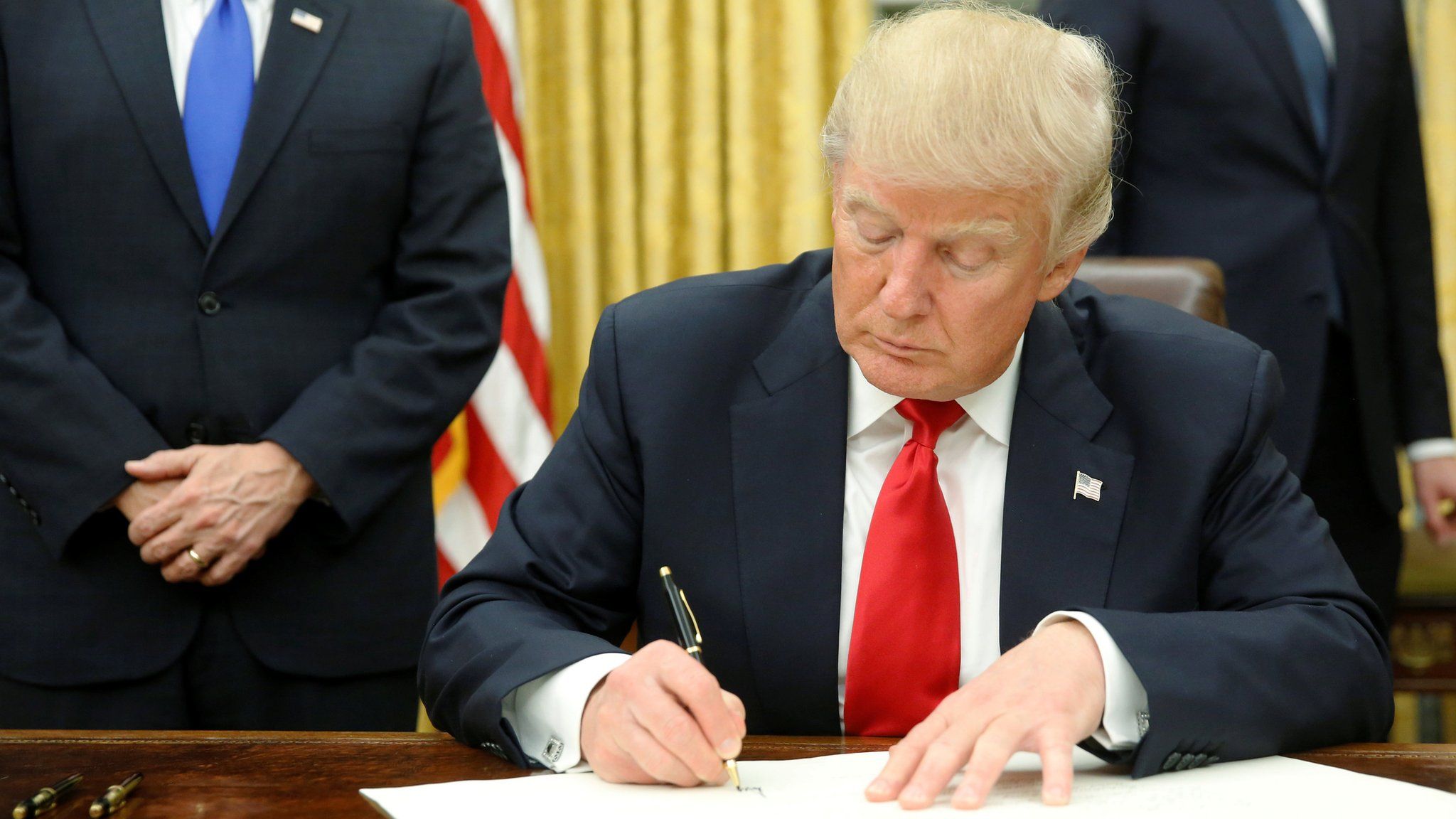 President Donald Trump signs first executive orders in Oval Office in Washington, January 20, 2017