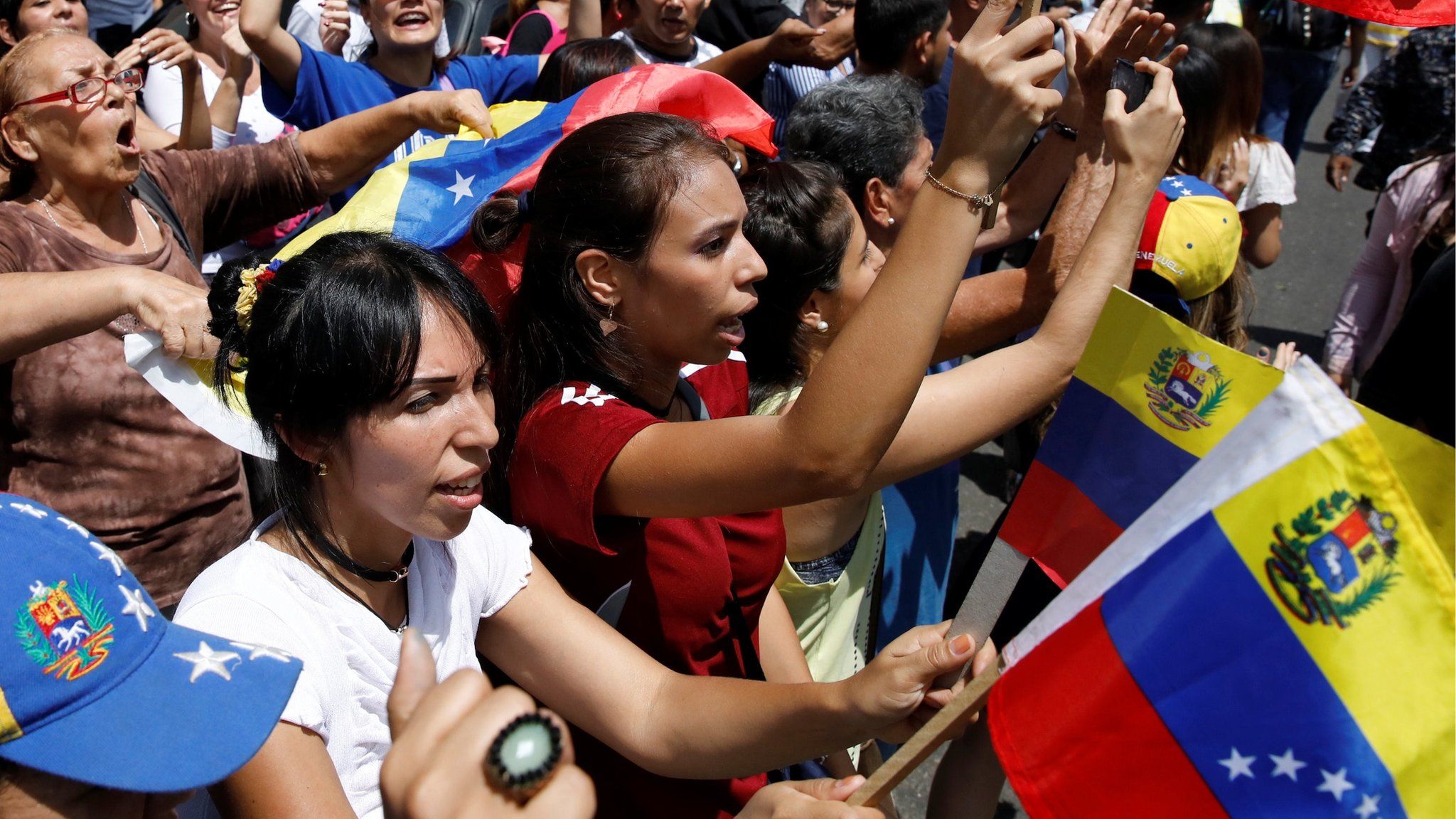 People chant slogans against President Maduro near a polling station in Caracas