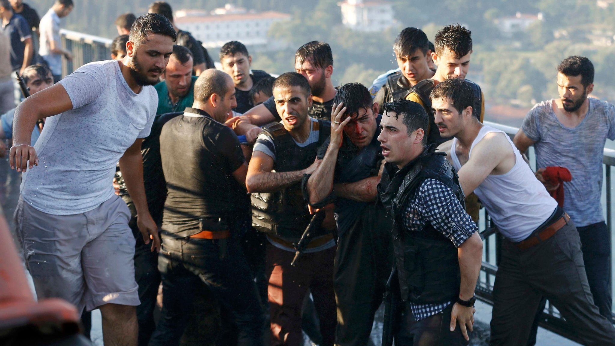 Policemen protect a soldier from a mob on the Bosphorus bridge in Istanbul on 16 July 2016