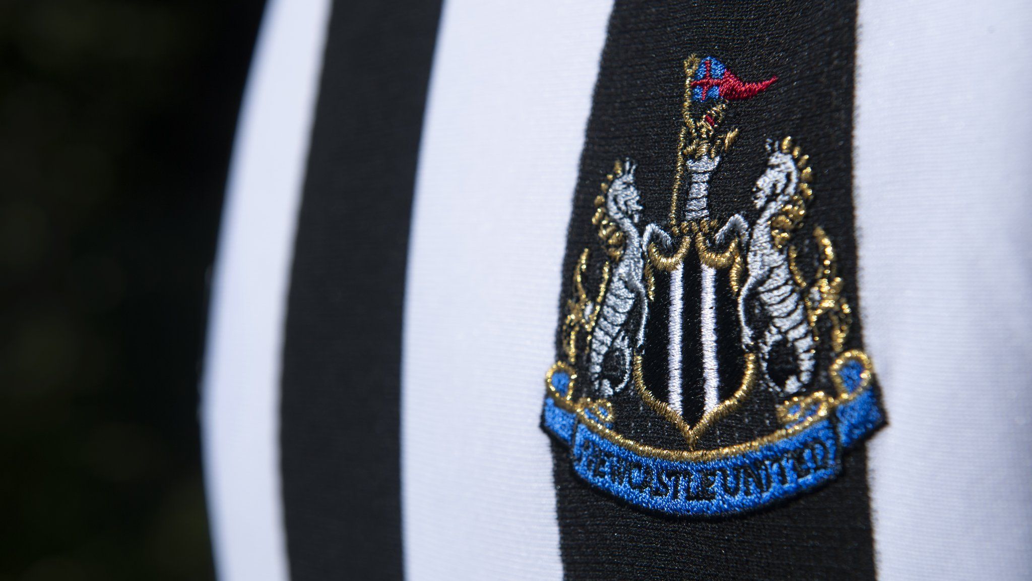 Newcastle United's crest on a first team shirt with black and white stripes