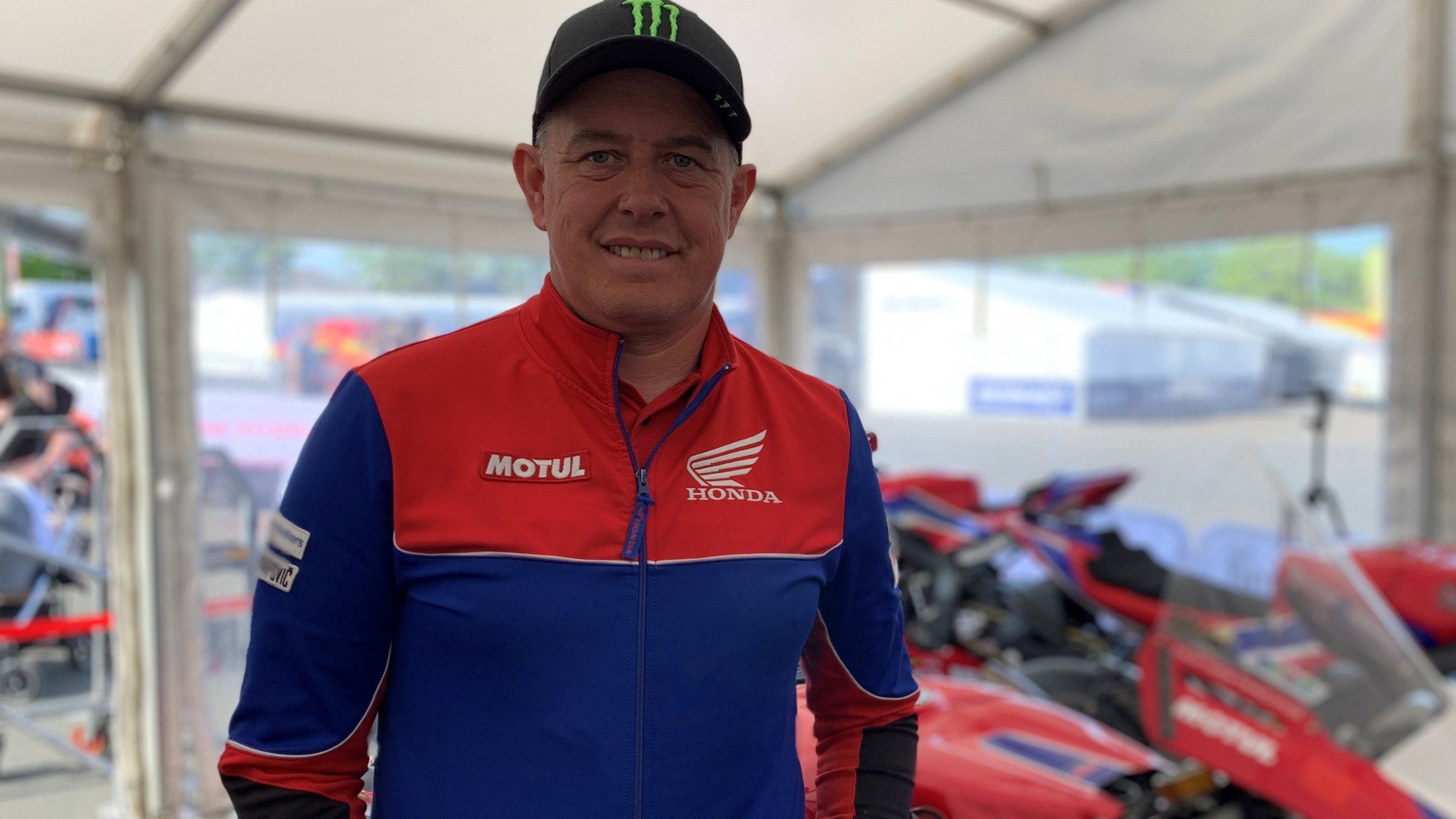 John McGuinness standing in front of a motorbike