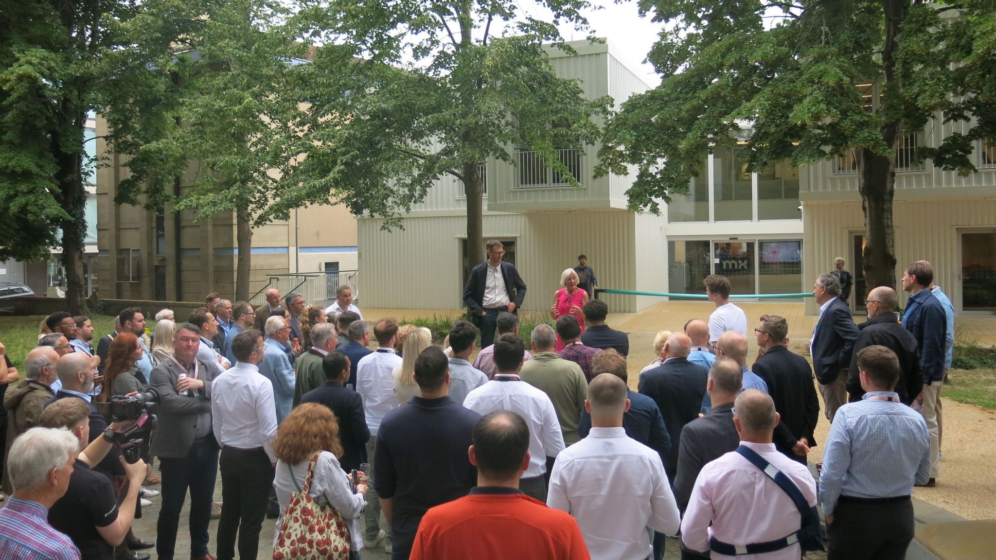 A crowd gathers as a ribbon is prepared to be cut outside Minster Exchange in Cheltenham