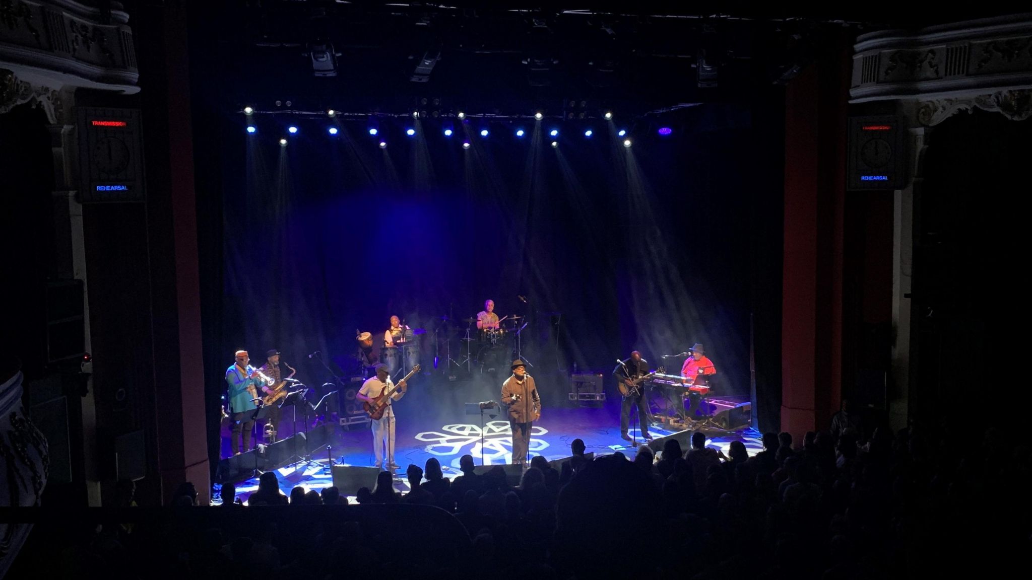 A band of nine members performs on stage inside O2 Shepherd's Bush Empire
