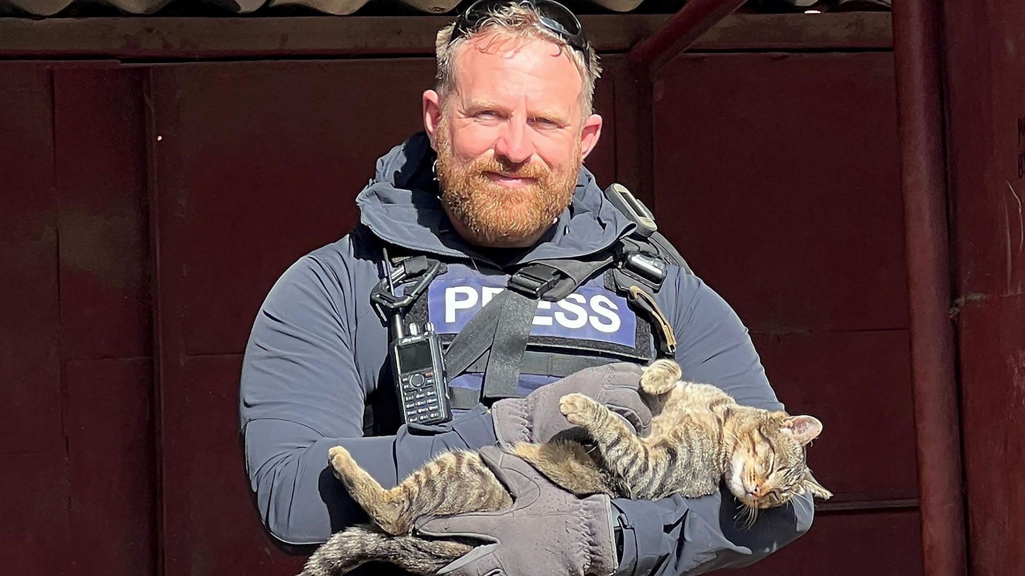 Reuters safety adviser Ryan Evans holds a cat that he found while working with a news reporting team