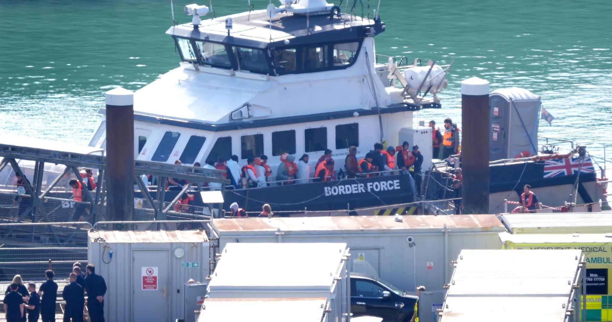 Migrants disembark a border force boat in Dover