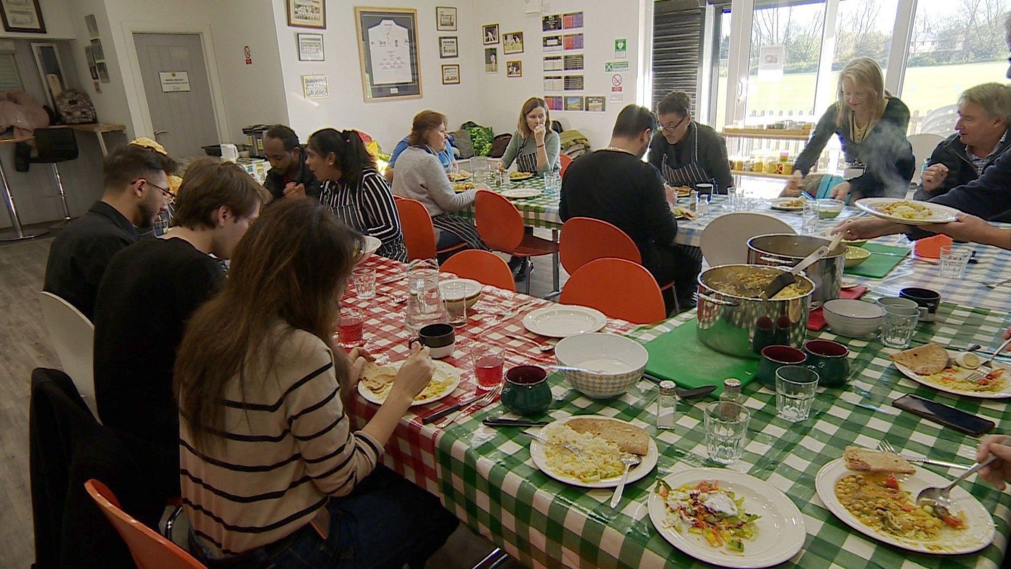 Refugees and asylum seekers having lunch with charity volunteers