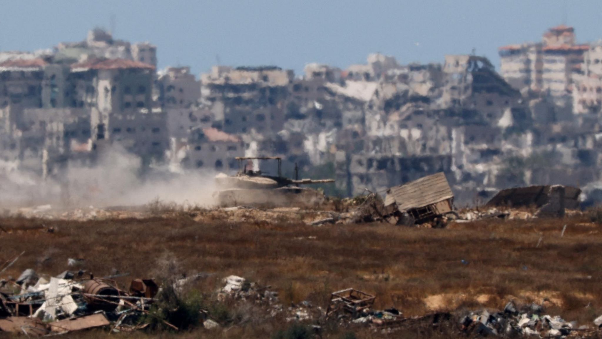 An Israeli tank manoeuvres inside the Gaza Strip, as seen from Israel (17 June 2024)