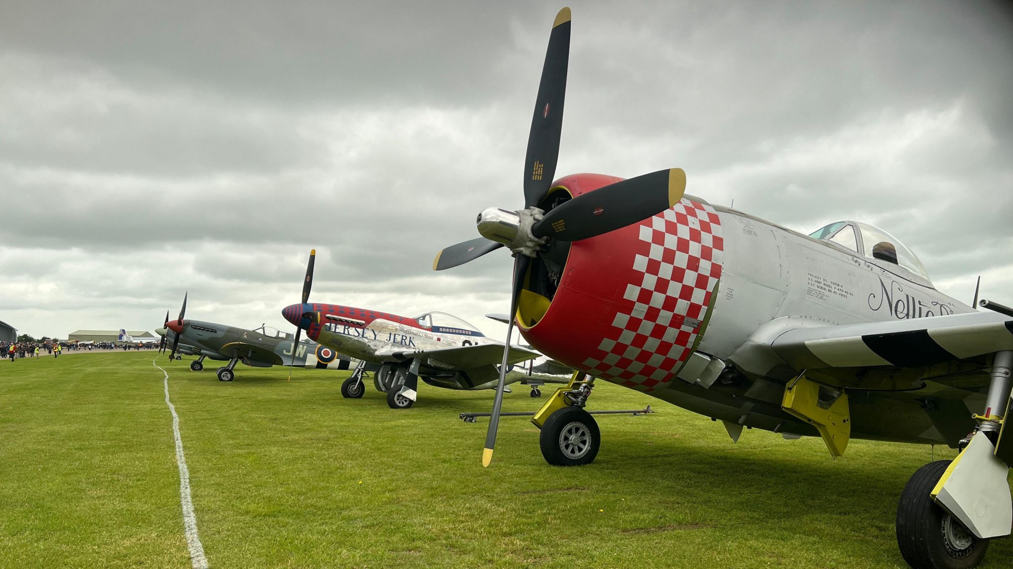 World War Two aircraft lined up on the grass at an overcast Imperial War Museum, Duxford