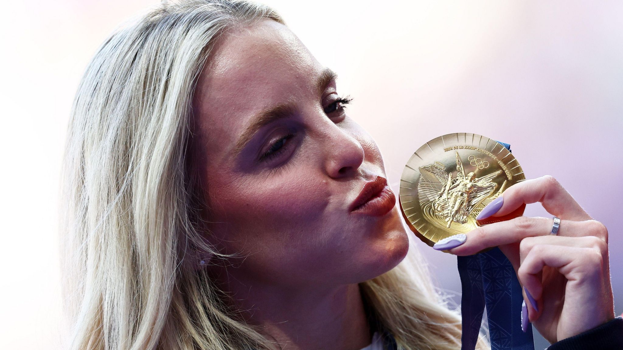 Keely Hodgkinson aims a kiss at her gold medal