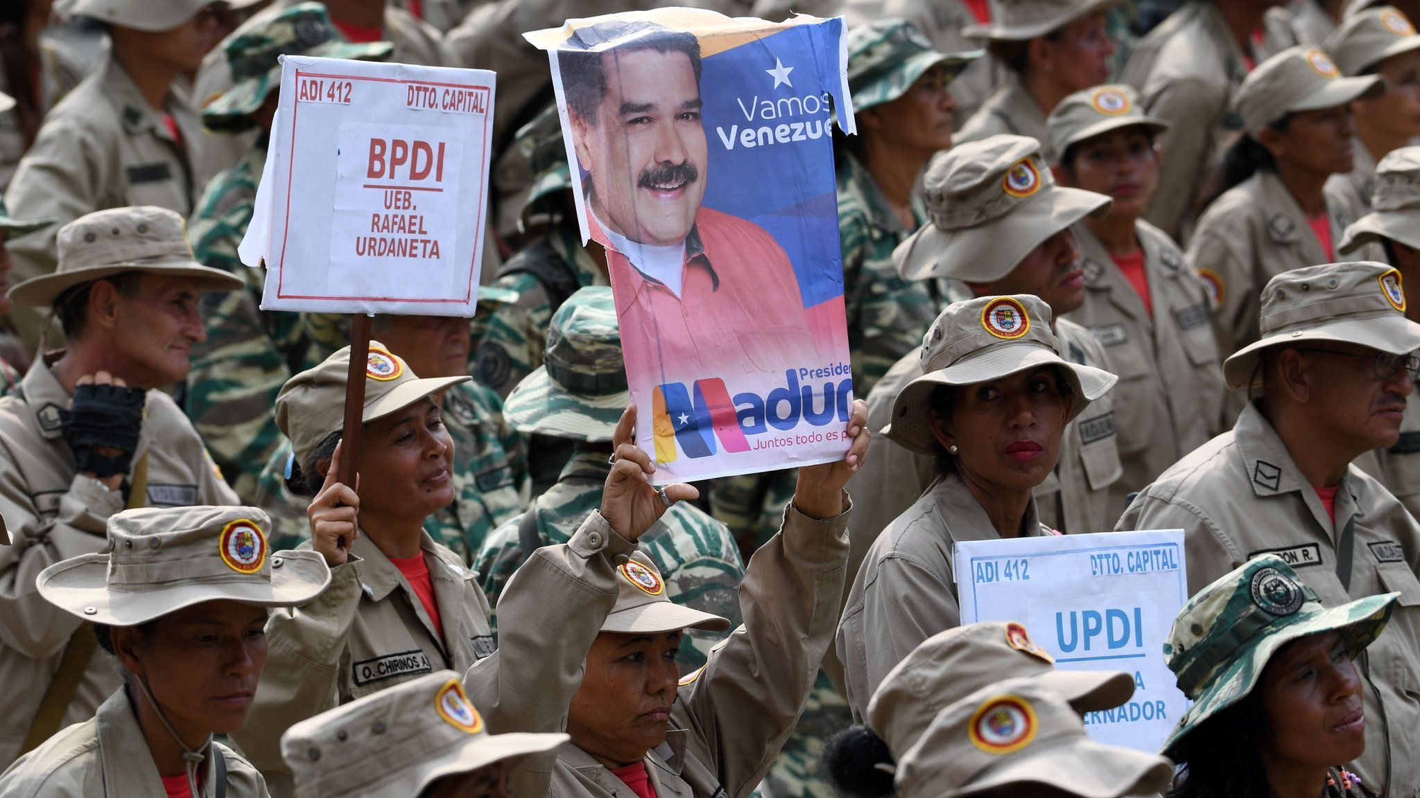A member of the Bolivarian Militia holds a poster of Venezuelan President Nicolás Maduro (Caracas, 13 April)