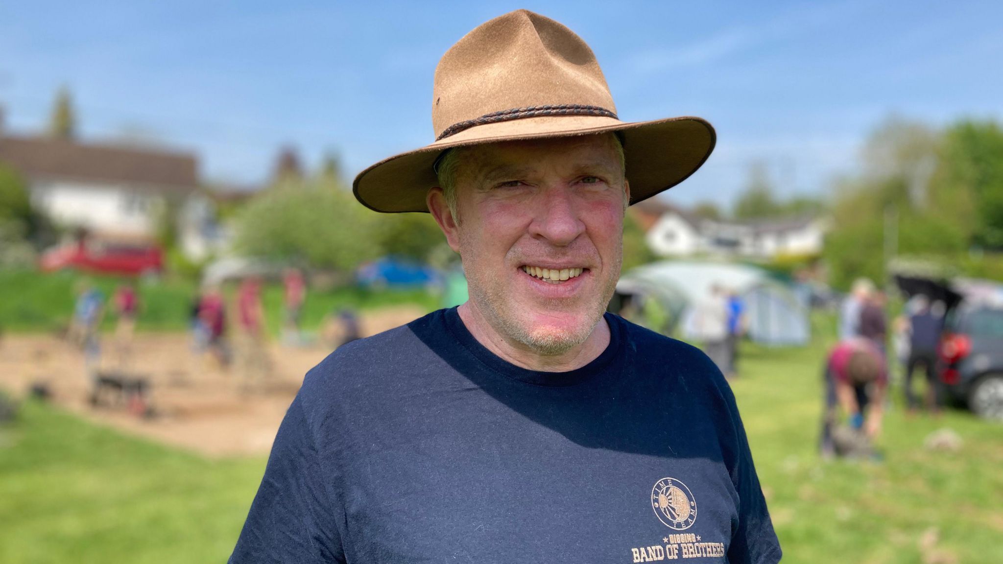 Richard Osgood wears a blue t-shirt and brimmed hat, looking at the camera