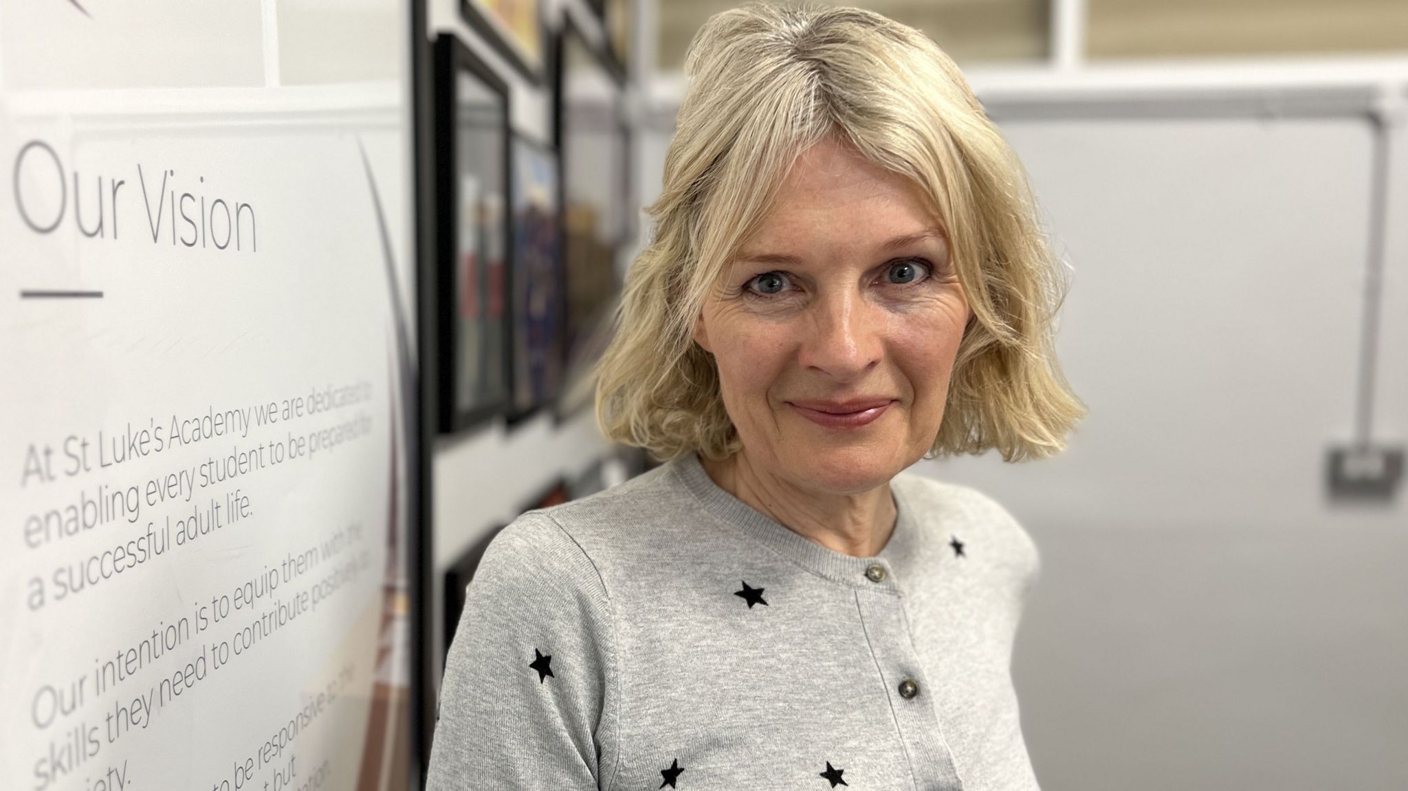 Judith Buckingham wearing a grey jumper with black stars, smiling