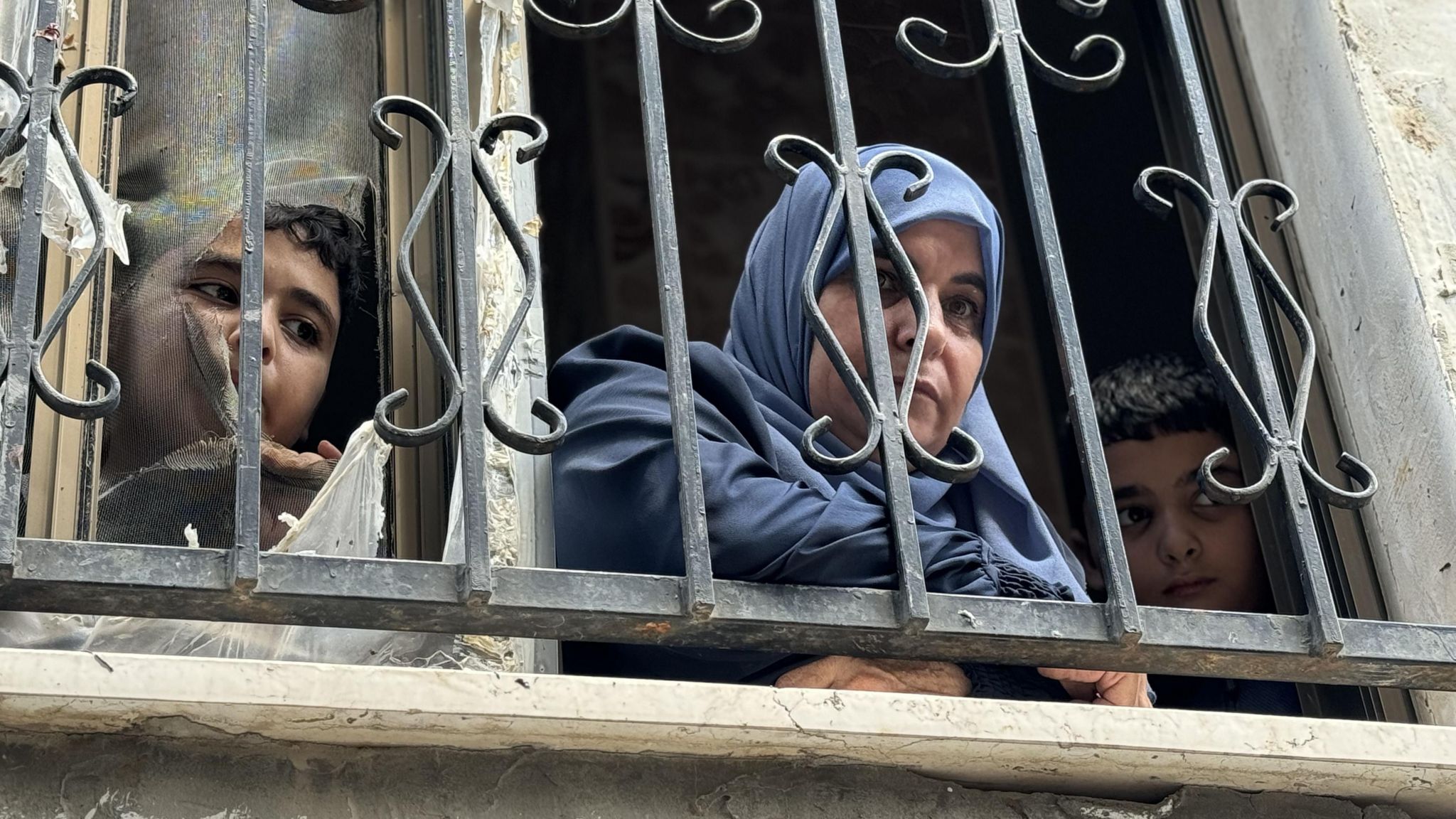 Umm Yazan looks out of the window of her home in Nur Shams refugee camp, in the occupied West Bank (30 August 2024)