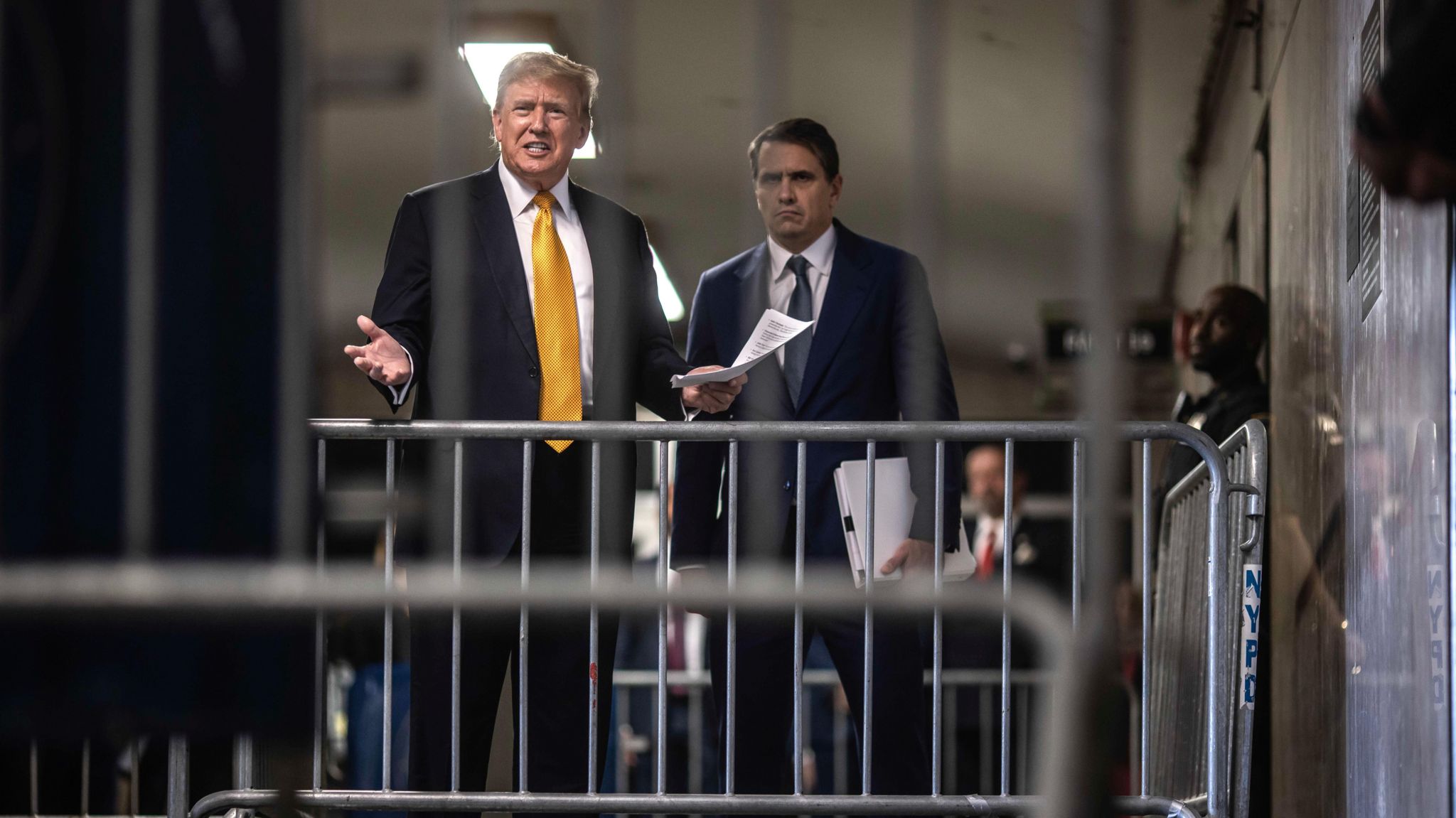 Donald Trump seen behind security barricades as he speaks to the media in the courthouse